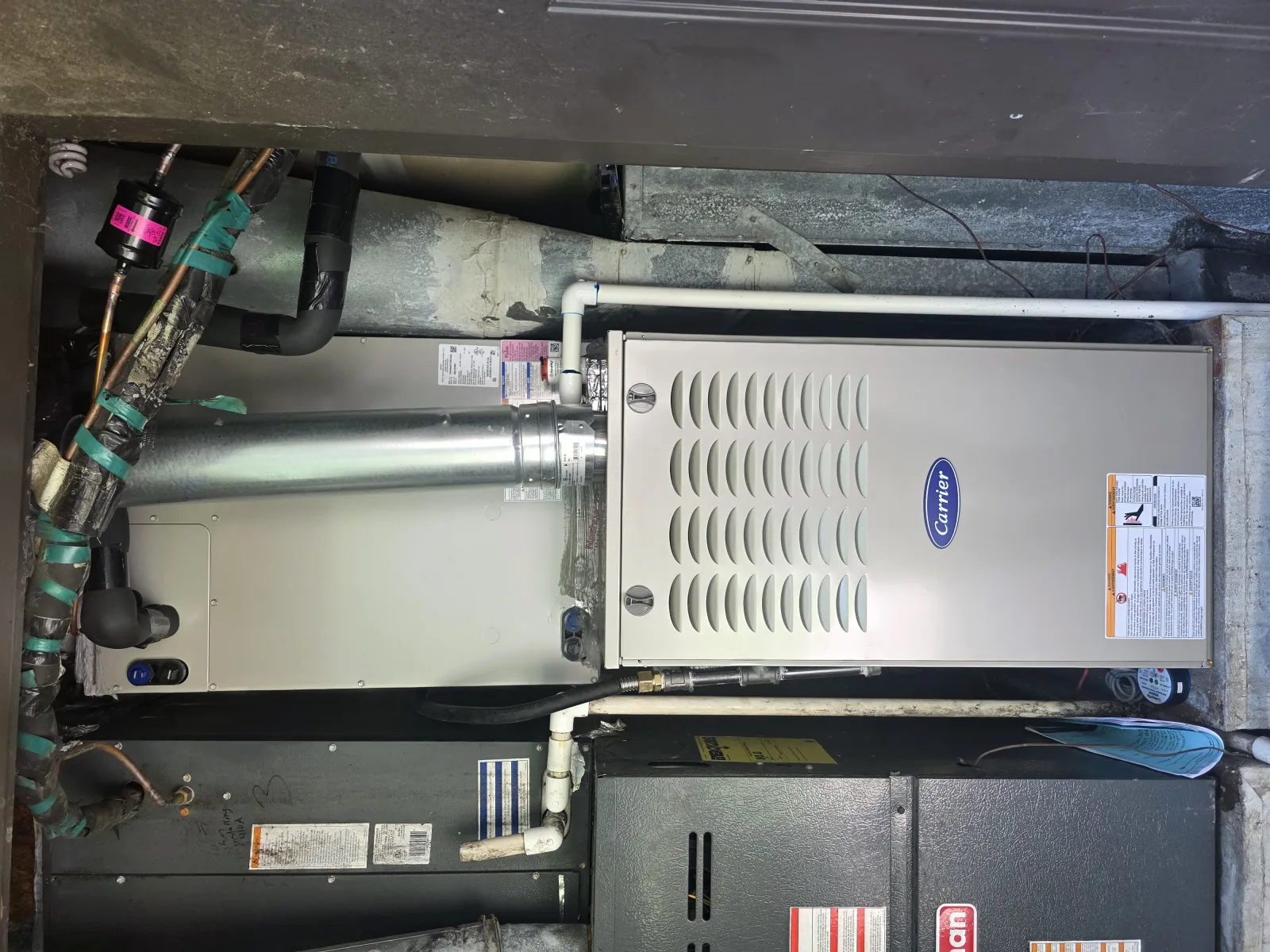 Residential HVAC system with Carrier furnace and ductwork installed in a utility room setting
