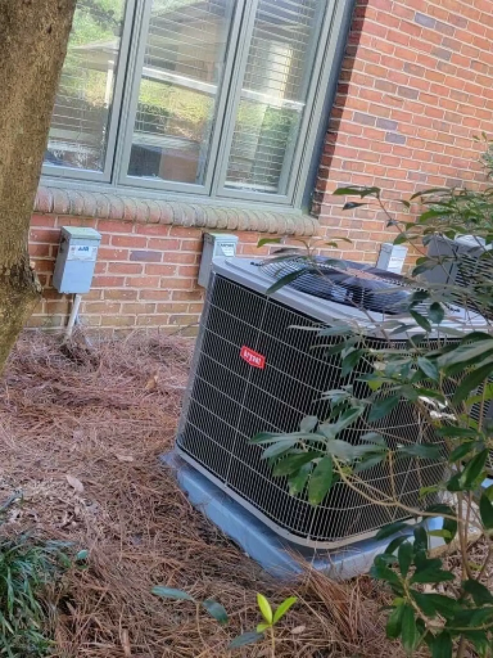 a black garbage can outside a brick building