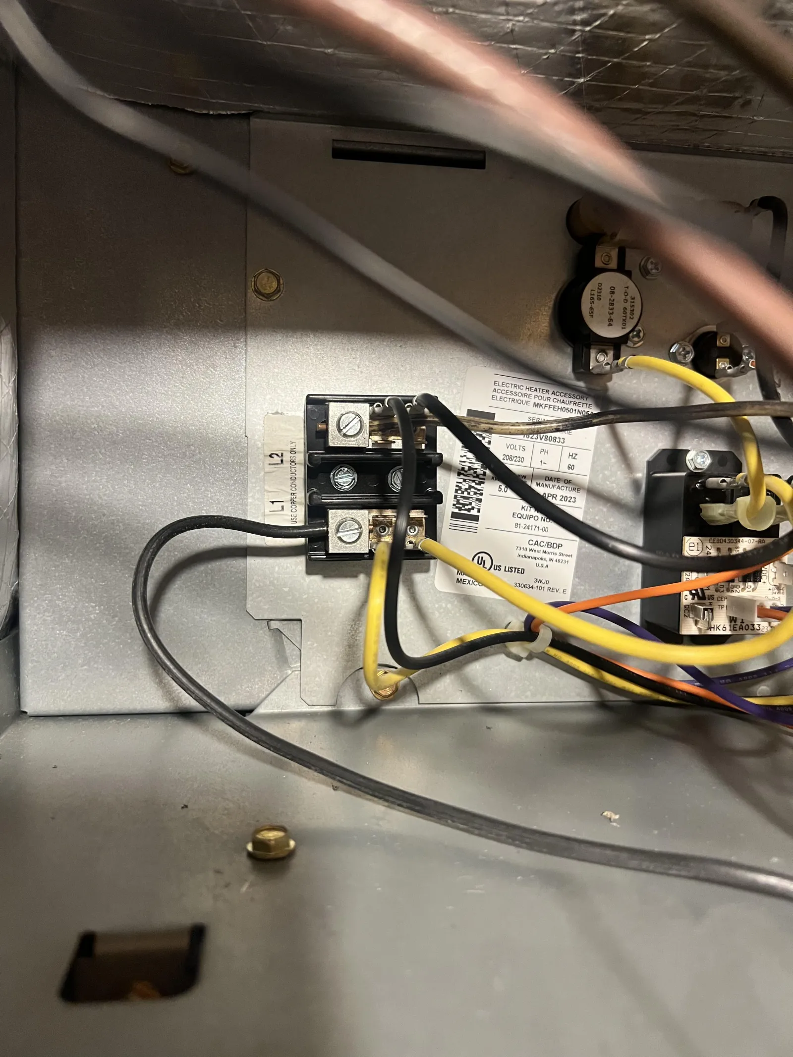 Marietta AC Cooling Air Conditioner Repair in 30067 by The Air Company of GA. Close-up of electrical wiring and components inside a metal panel, showing black, yellow, and orange wires.