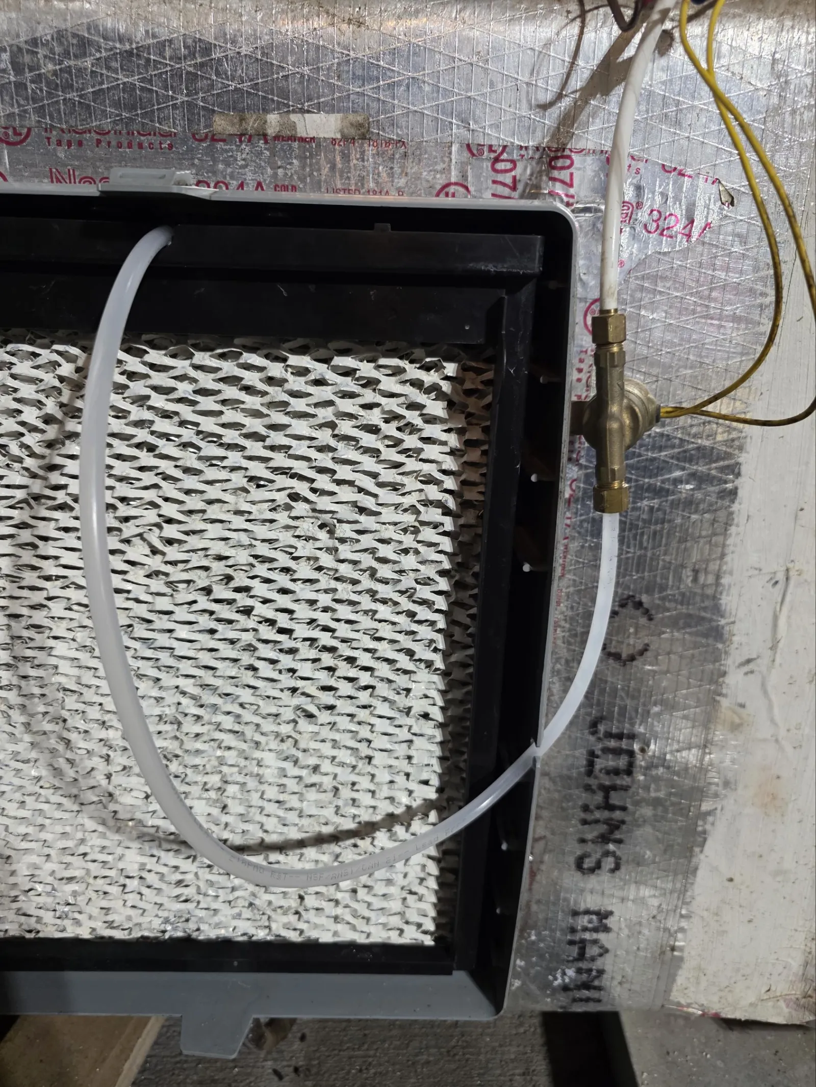 AC Cooling Repair in Atlanta 30306 by The Air Company of GA.  Air conditioning evaporator coil with connected clear tubing and brass valve on insulated background.