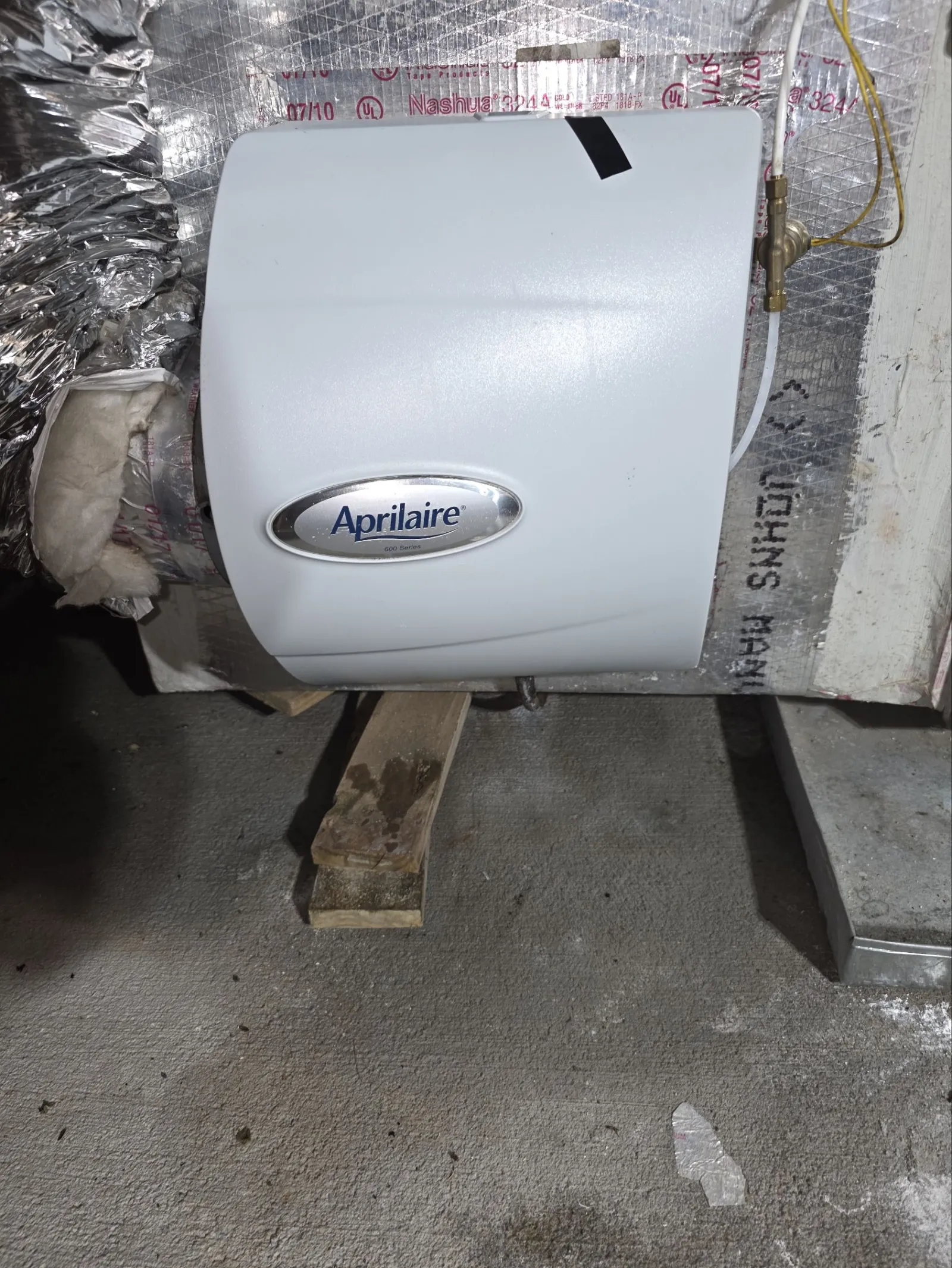 AC Cooling Repair in Atlanta 30306 by The Air Company of GA.  Aprilaire humidifier unit installed on ductwork with insulation and pipes in basement area.