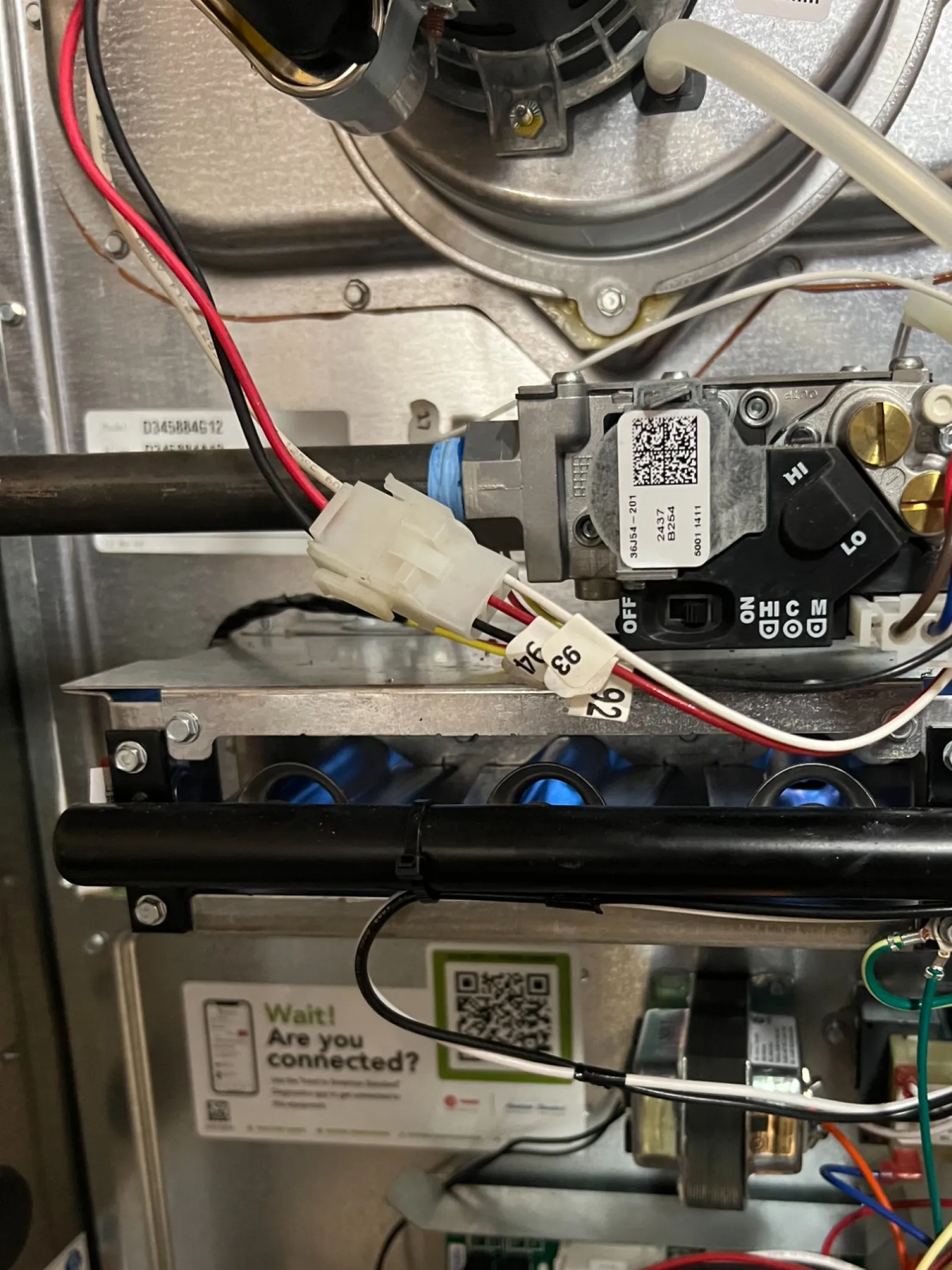 AC Repair in Roswell GA by The Air Company of GA. Close-up of complex furnace wiring and control components inside metal casing with various wires and circuit boards.