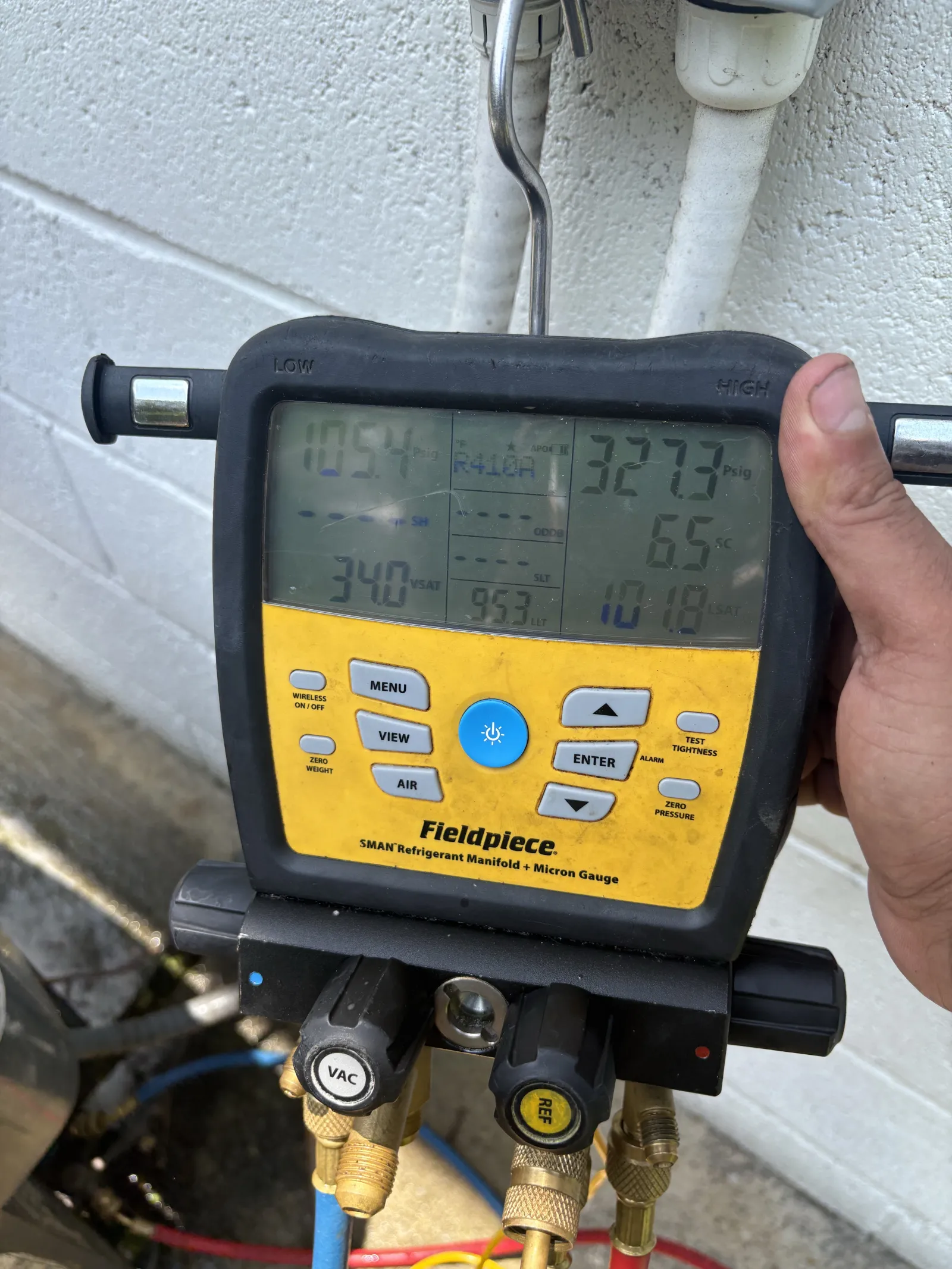 Fieldpiece SMAN refrigerant manifold with micron gauge displaying pressure and temperature readings.