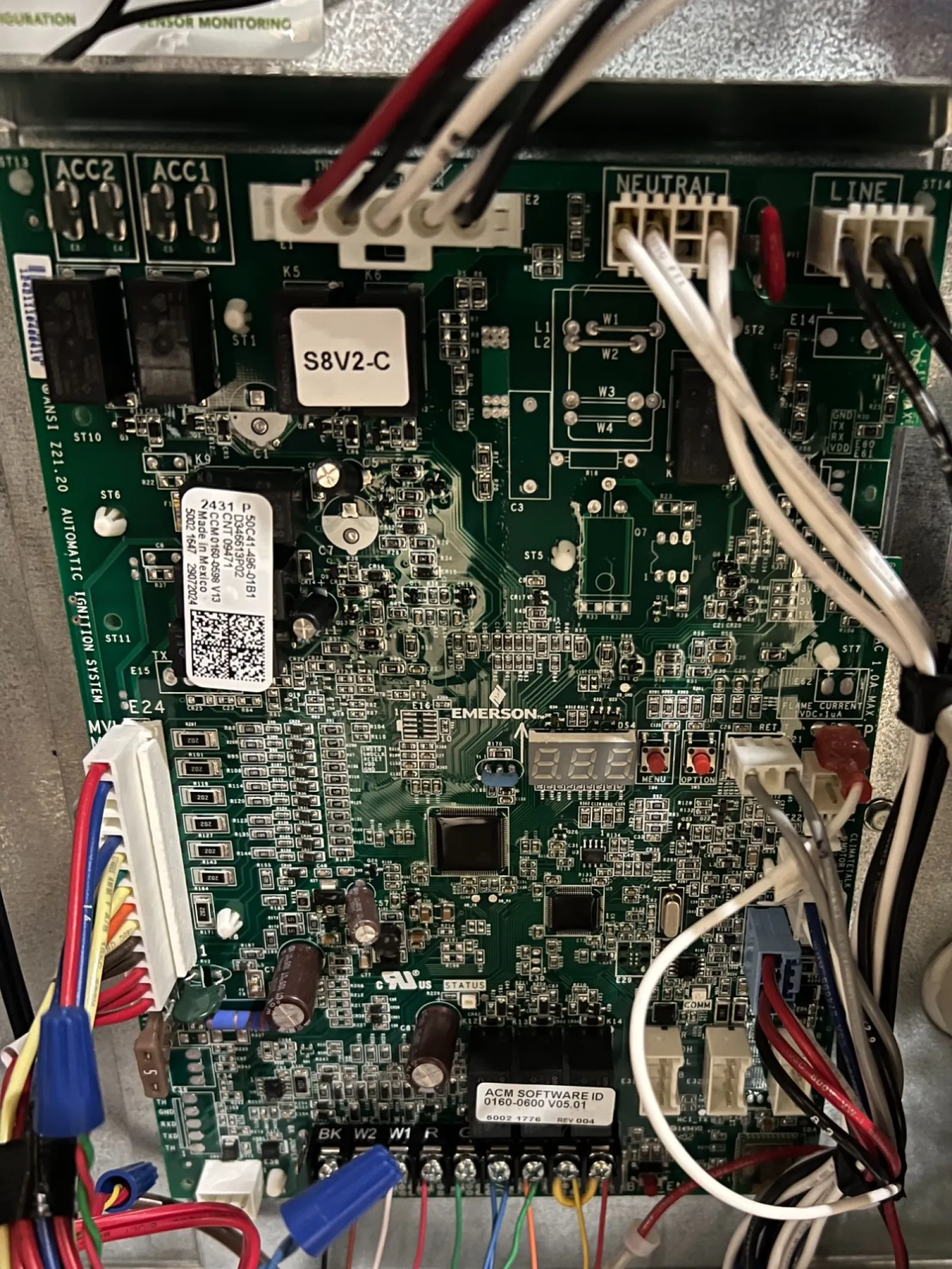 AC Repair in Roswell GA by The Air Company of GA. Close-up of a complex electronic circuit board with multicolored wires connected inside a device.