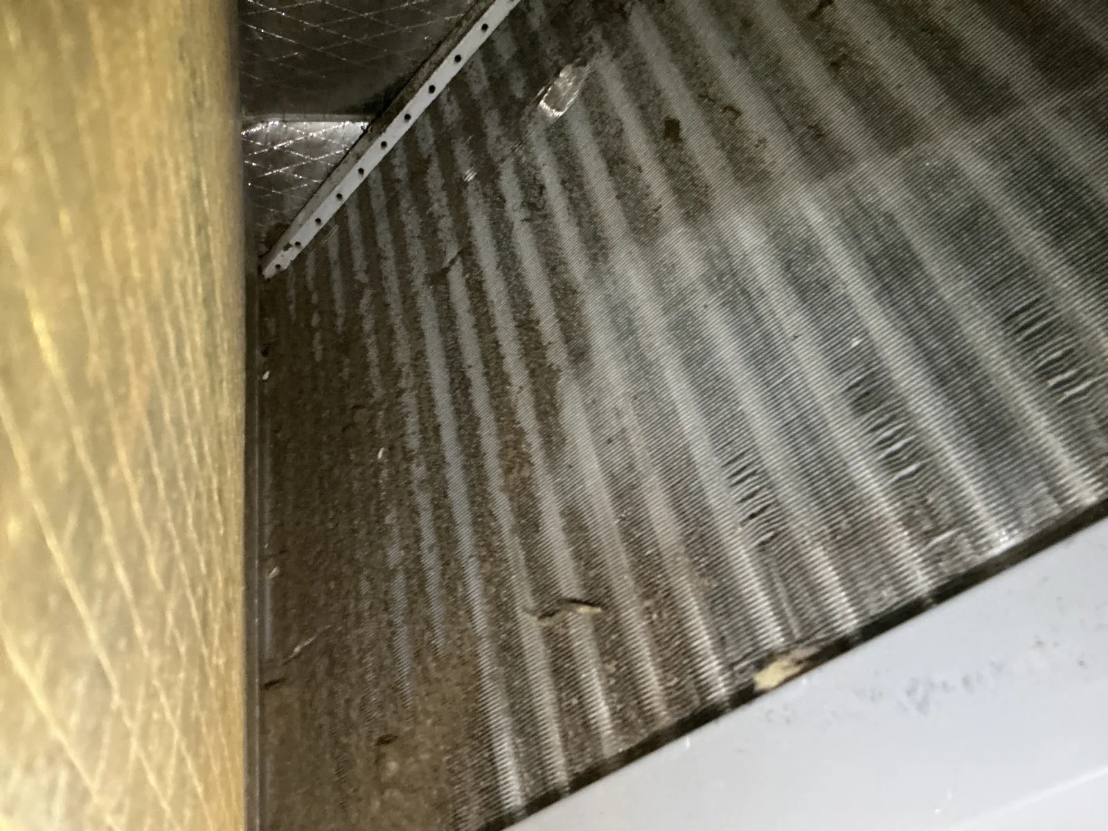 Dirty HVAC air filter covered with dust and debris, showing need for cleaning or replacement.