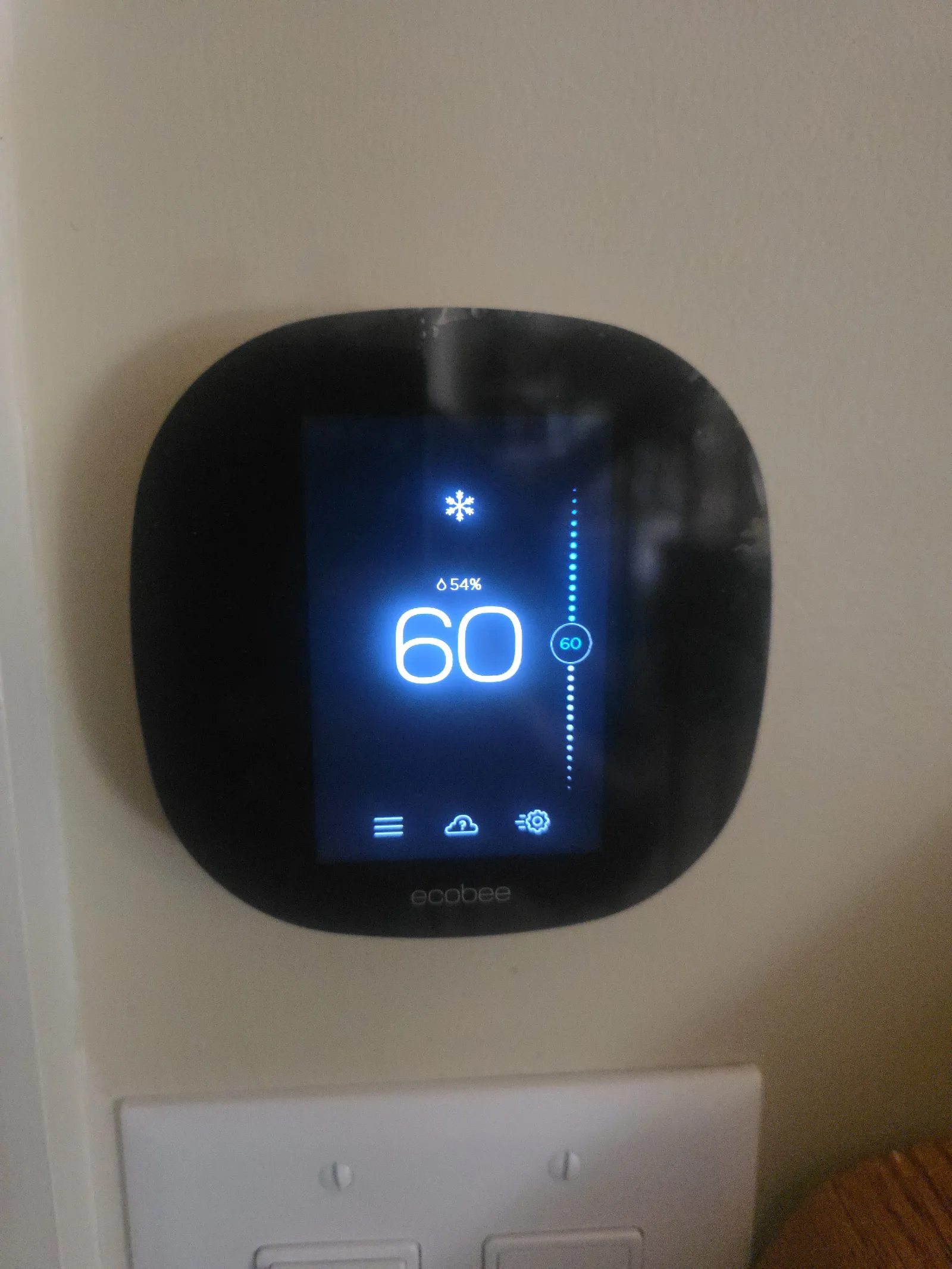 Ecobee thermostat set to 60 degrees Fahrenheit with 54% humidity and cooling mode active on a wall.