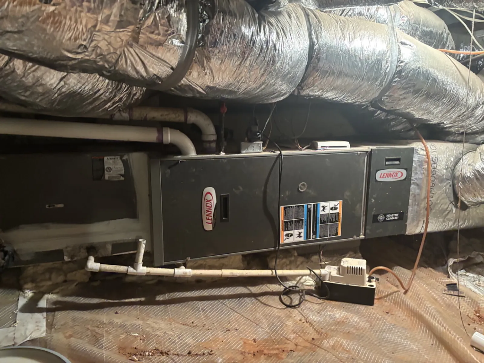 Lennox HVAC unit installed in a basement with insulated ductwork and PVC piping