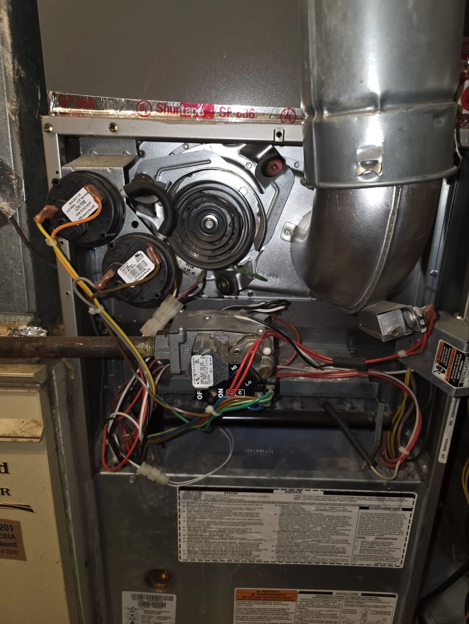 Air Conditioner AC Cooling Repair in Atlanta 30305 by The Air Company of GA.  Open furnace showing blower motor, gas valve, wiring, and metal ductwork inside HVAC system.