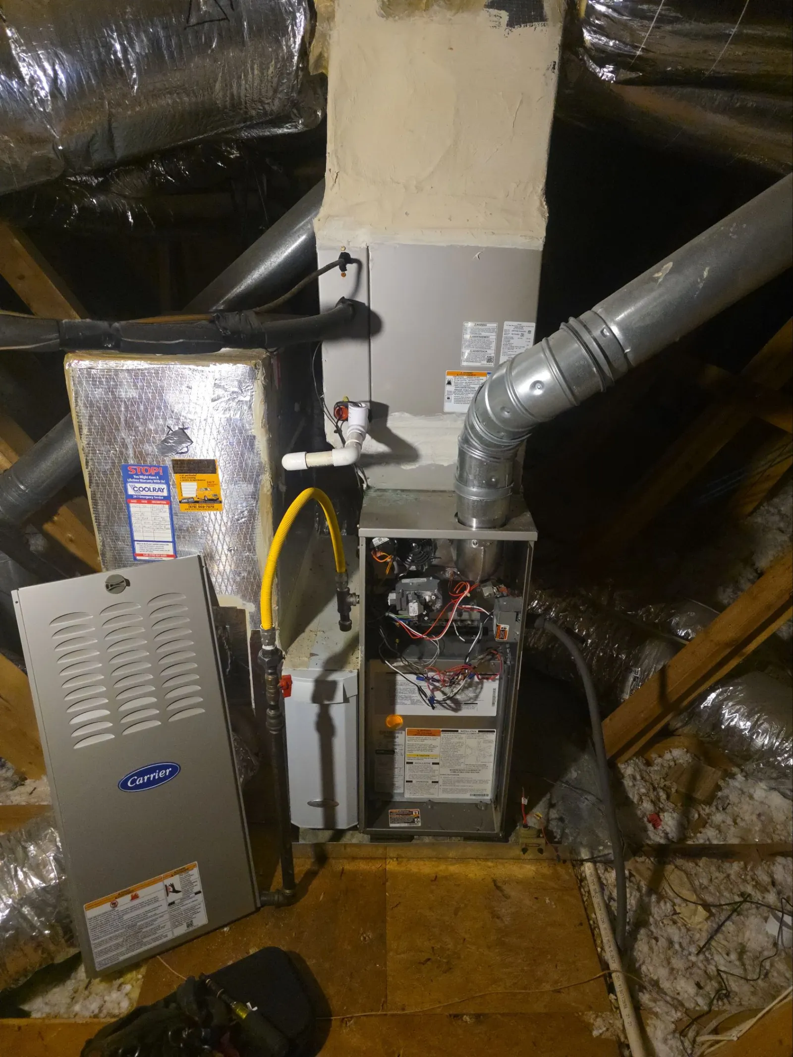 AC Air Conditioning Repair in Roswell 30075 by The Air Company of GA.  Furnace with exposed wiring and metal ducts installed in an attic with insulation and wooden beams.