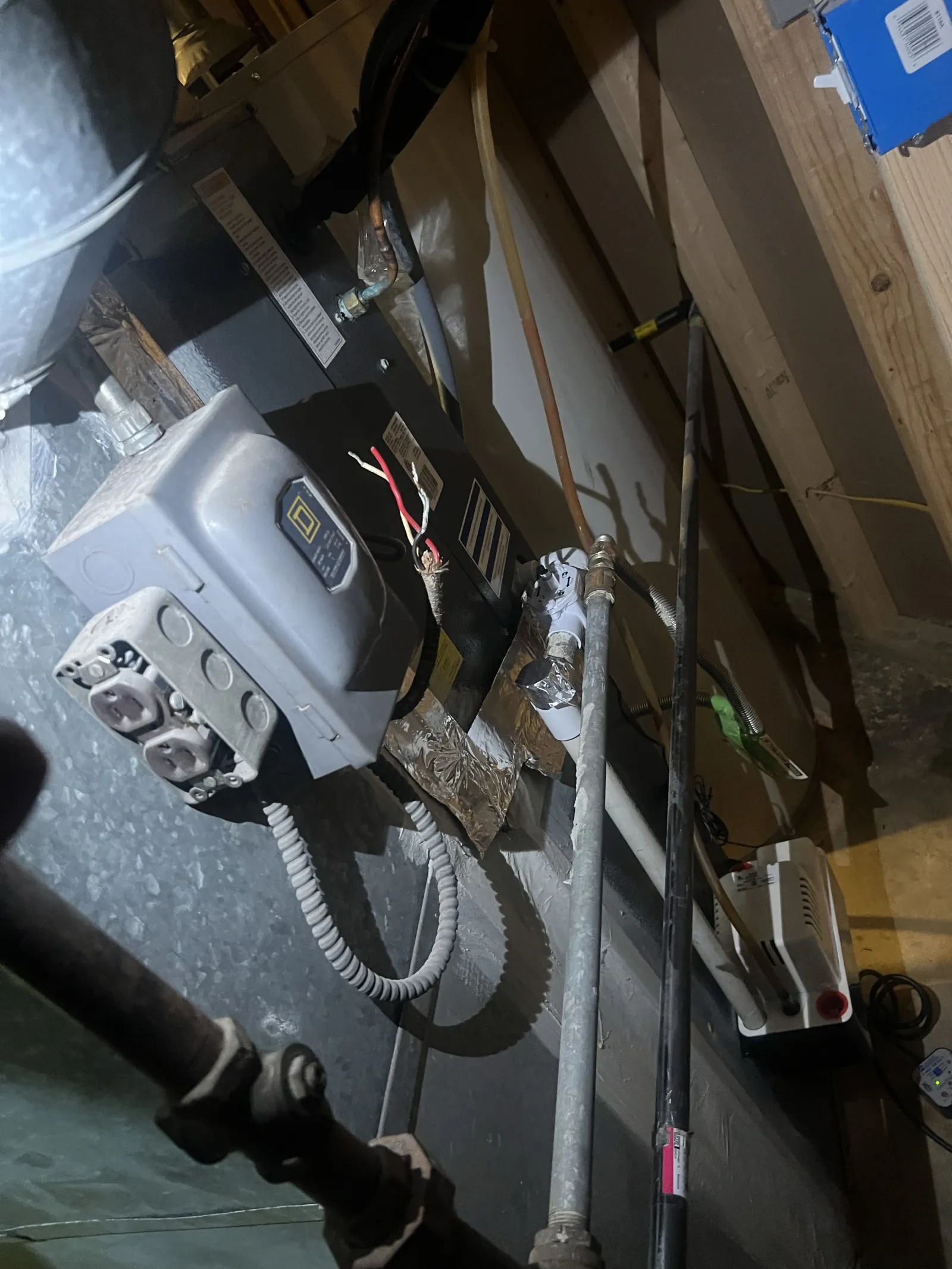 View of an HVAC system with electrical components, pipes, and wiring in a basement or utility room.