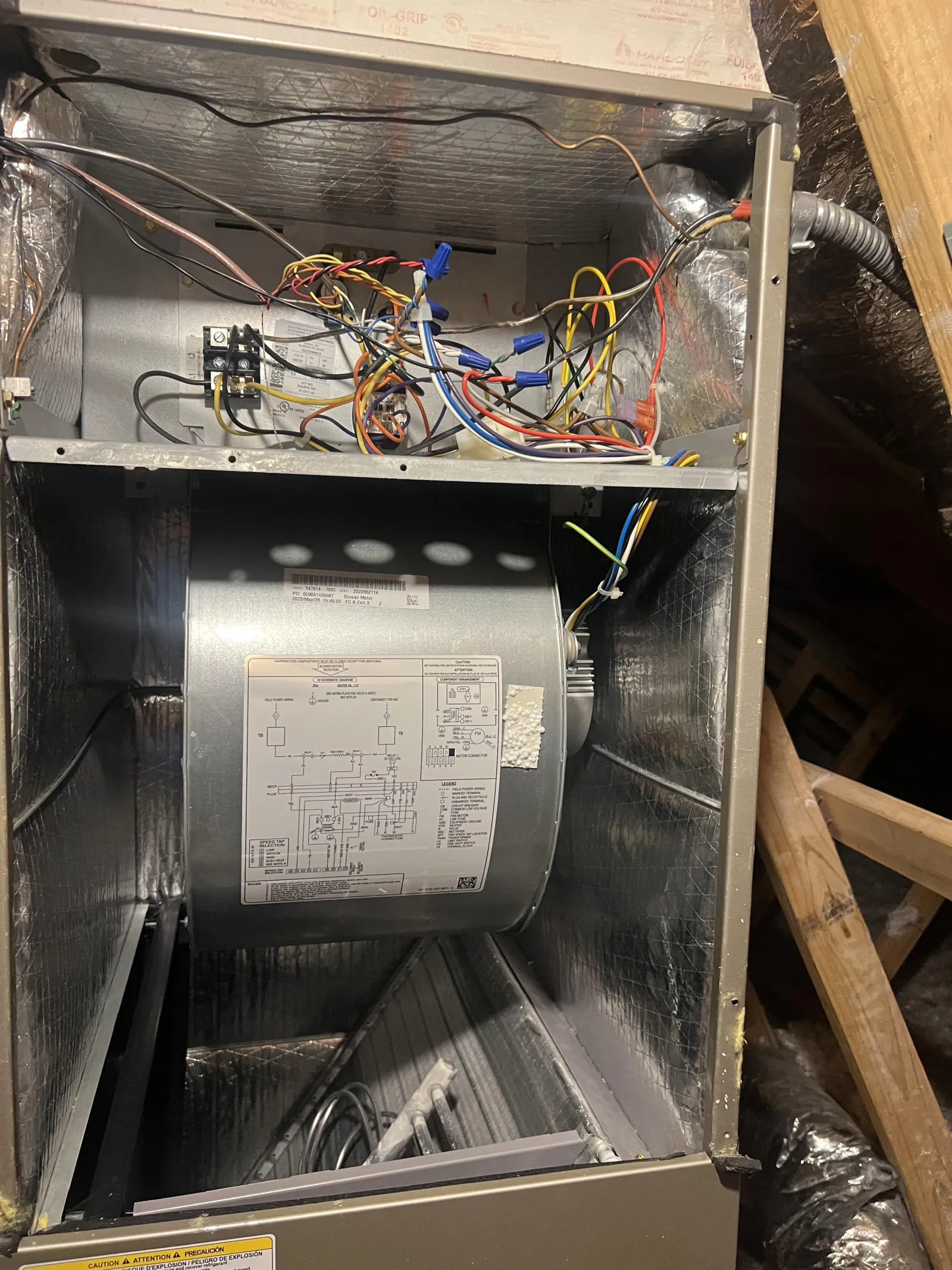 Marietta AC Cooling Air Conditioner Repair in 30067 by The Air Company of GA. Inside view of an HVAC furnace showing wiring, a blower motor with a wiring diagram, and metal insulation panels.