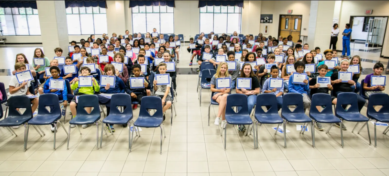 a group of people sitting in chairs with laptops in their hands