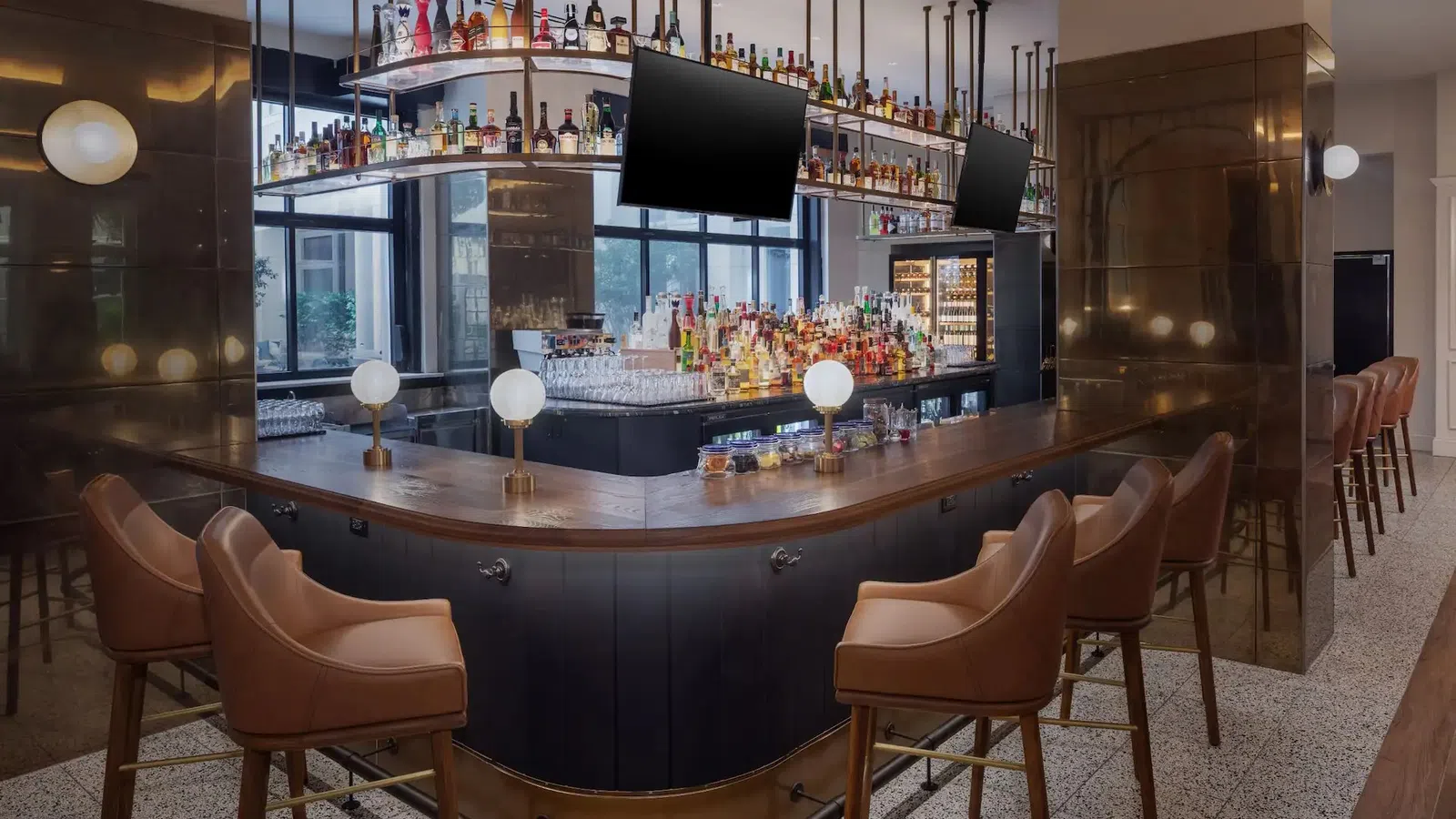 The Lowline by Hyatt JDV Hotel Custom Bar Millwork, Suspended Metal-and-Glass Liquor Shelving, Decorative Metal Focal Walls, and Island Quartz Countertop