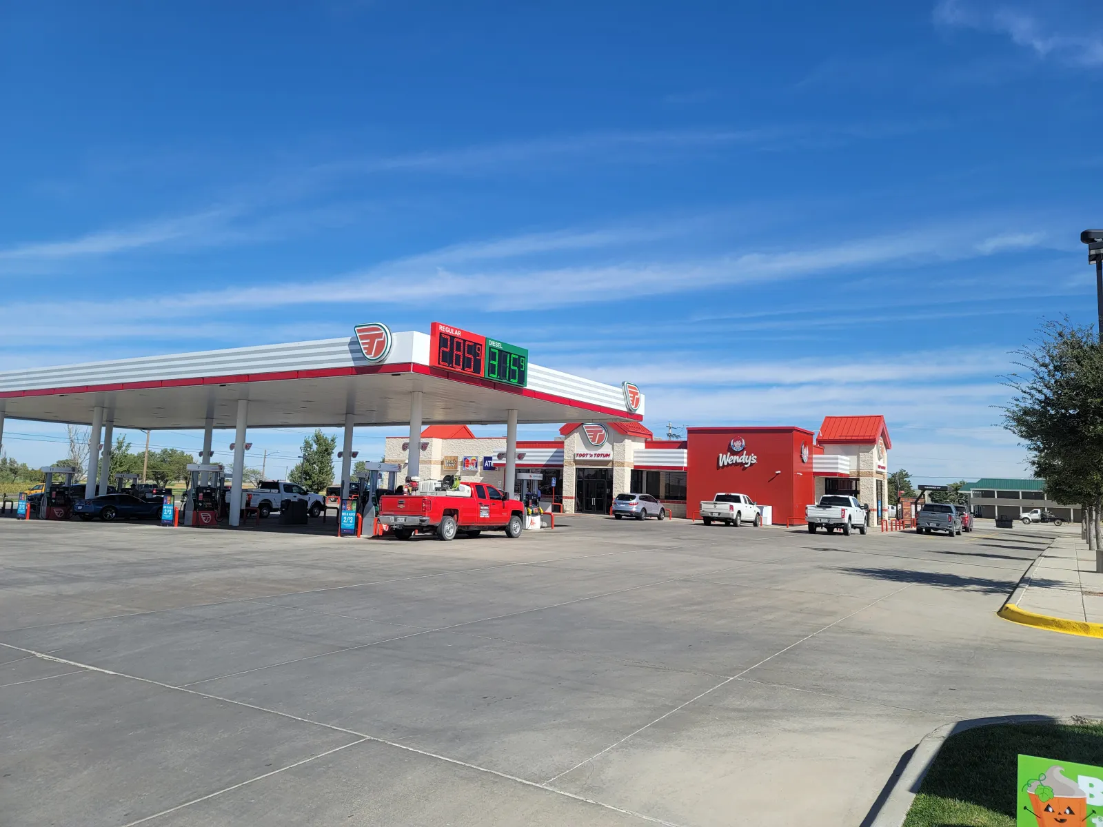 a gas station with cars parked at the gas station