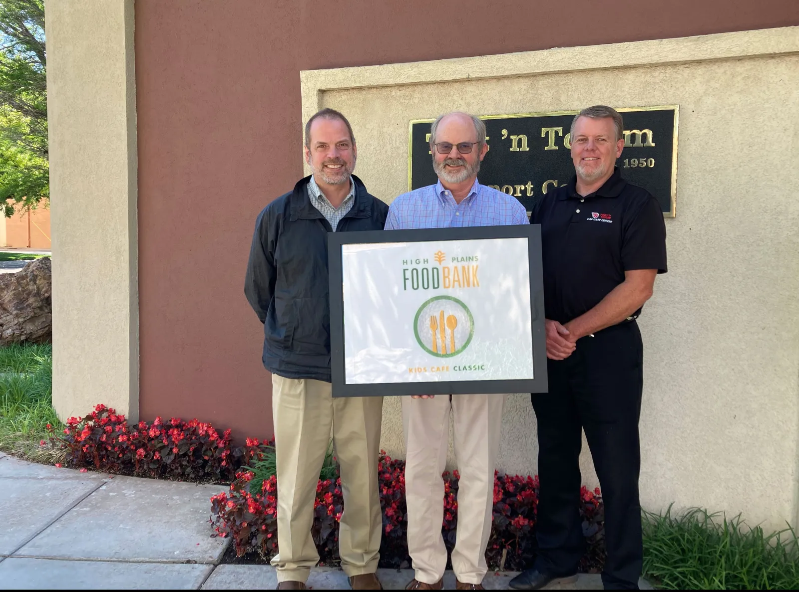 a few men holding a plaque