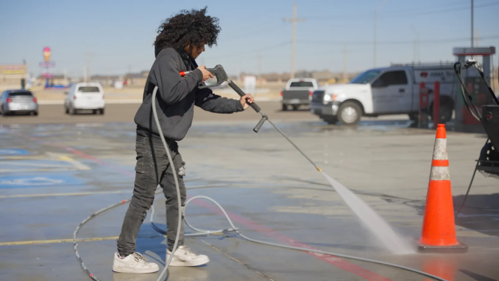 a person using a hose to water a road