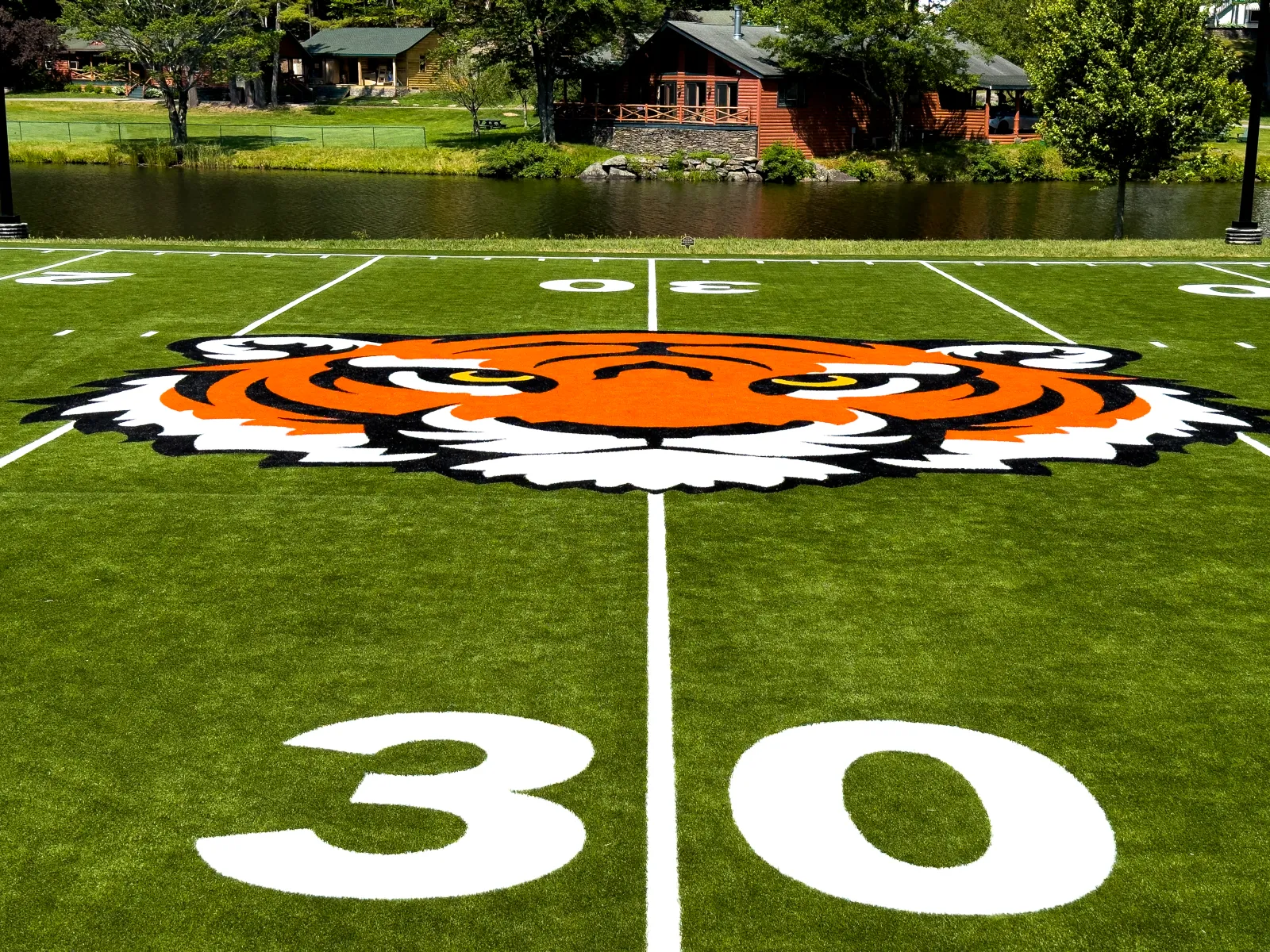 a football field with a painted football field and a house in the background