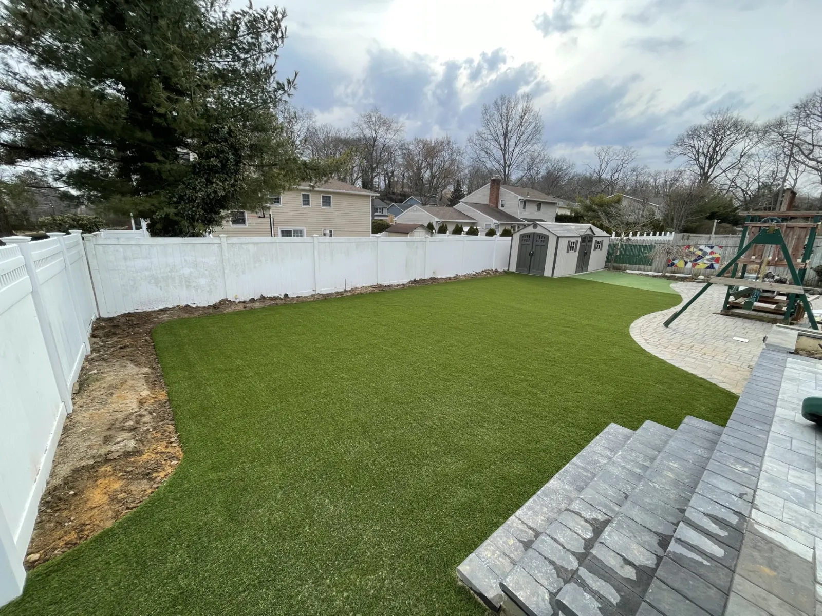 a backyard with a fence and a white fence