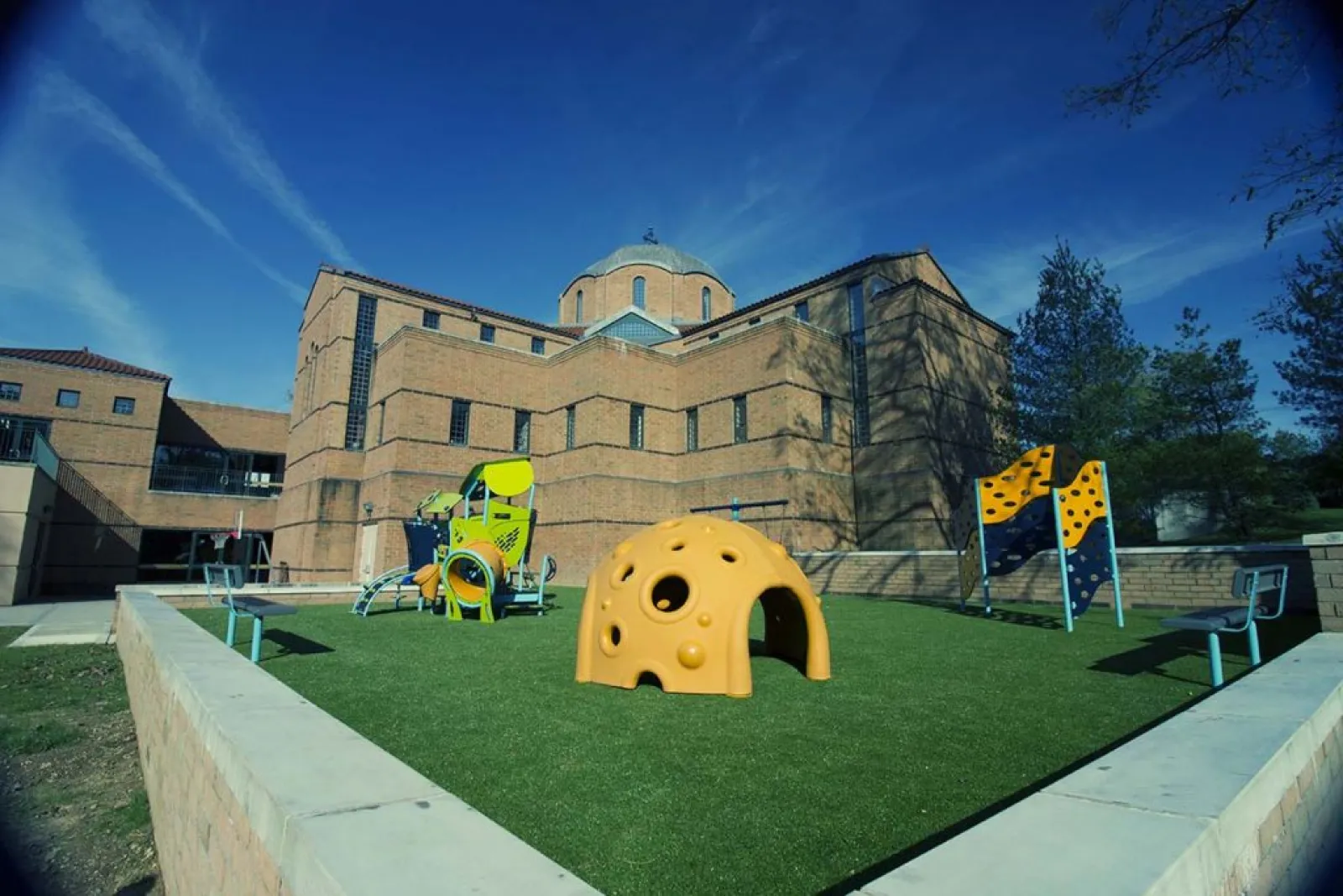 a large building with a lawn and a playground in front of it