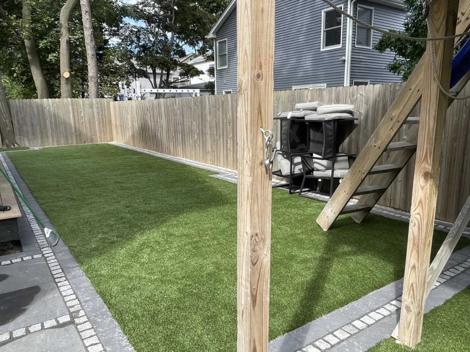 a backyard with a grill and a wood fence