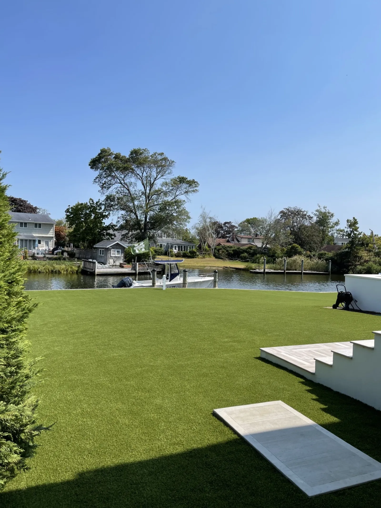 a lawn with a pond and a house in the background