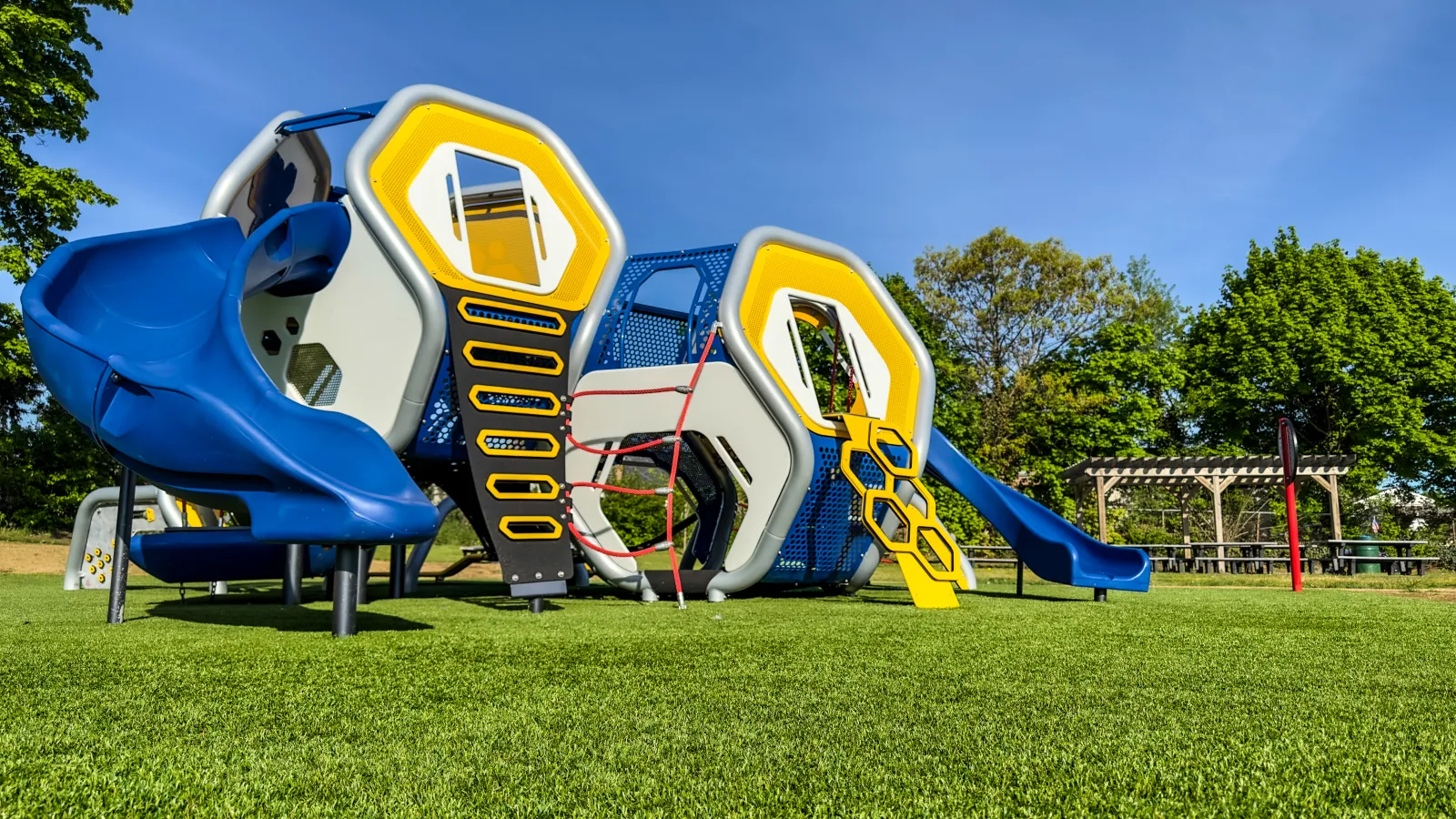 a yellow and blue playground slide with Disney's Pop Century Resort in the background