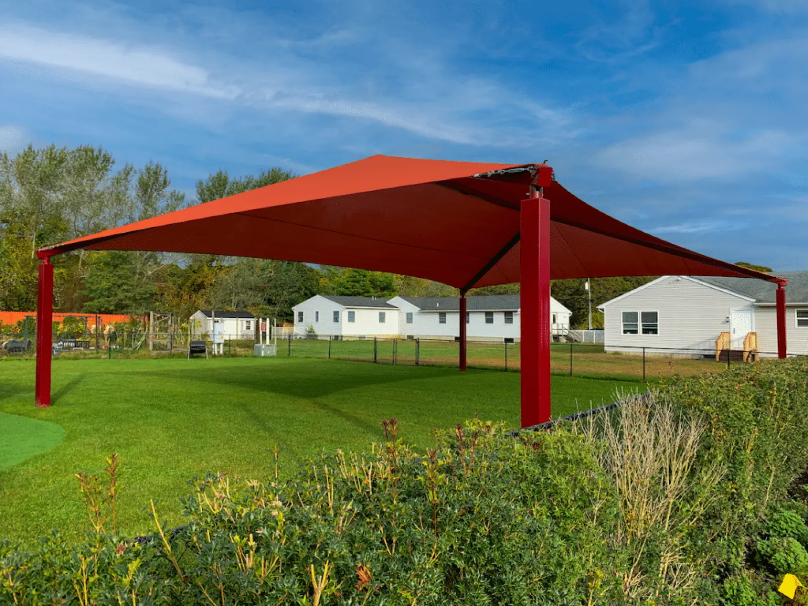 a red structure in a grassy field