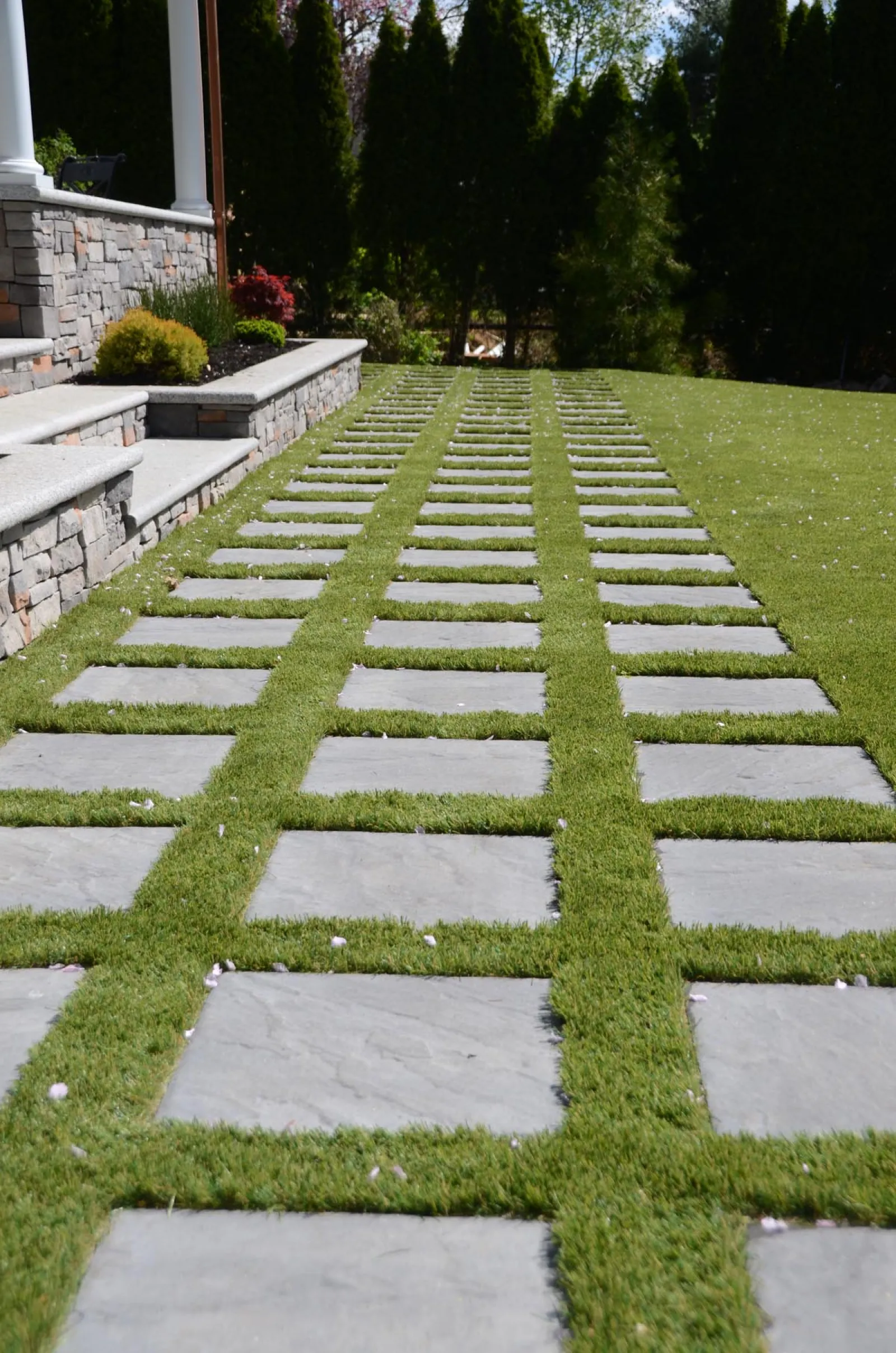 a green lawn with a stone walkway