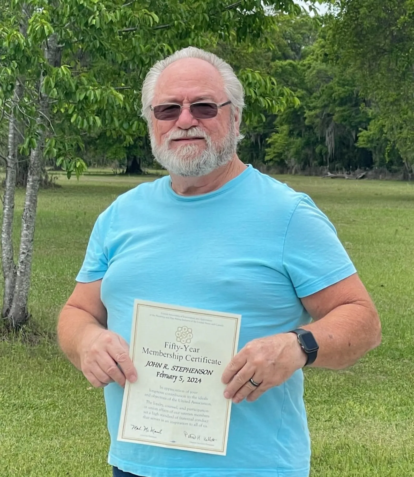 Ken Bates holding a certificate