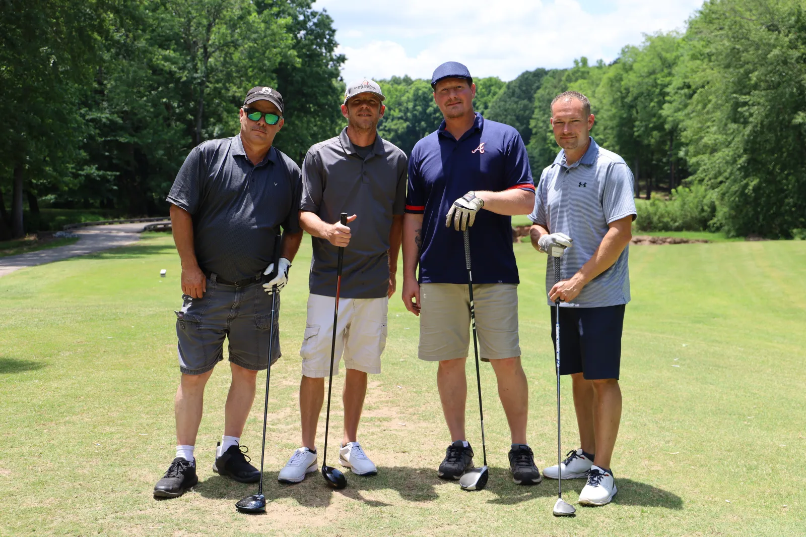 a group of men standing on a golf course