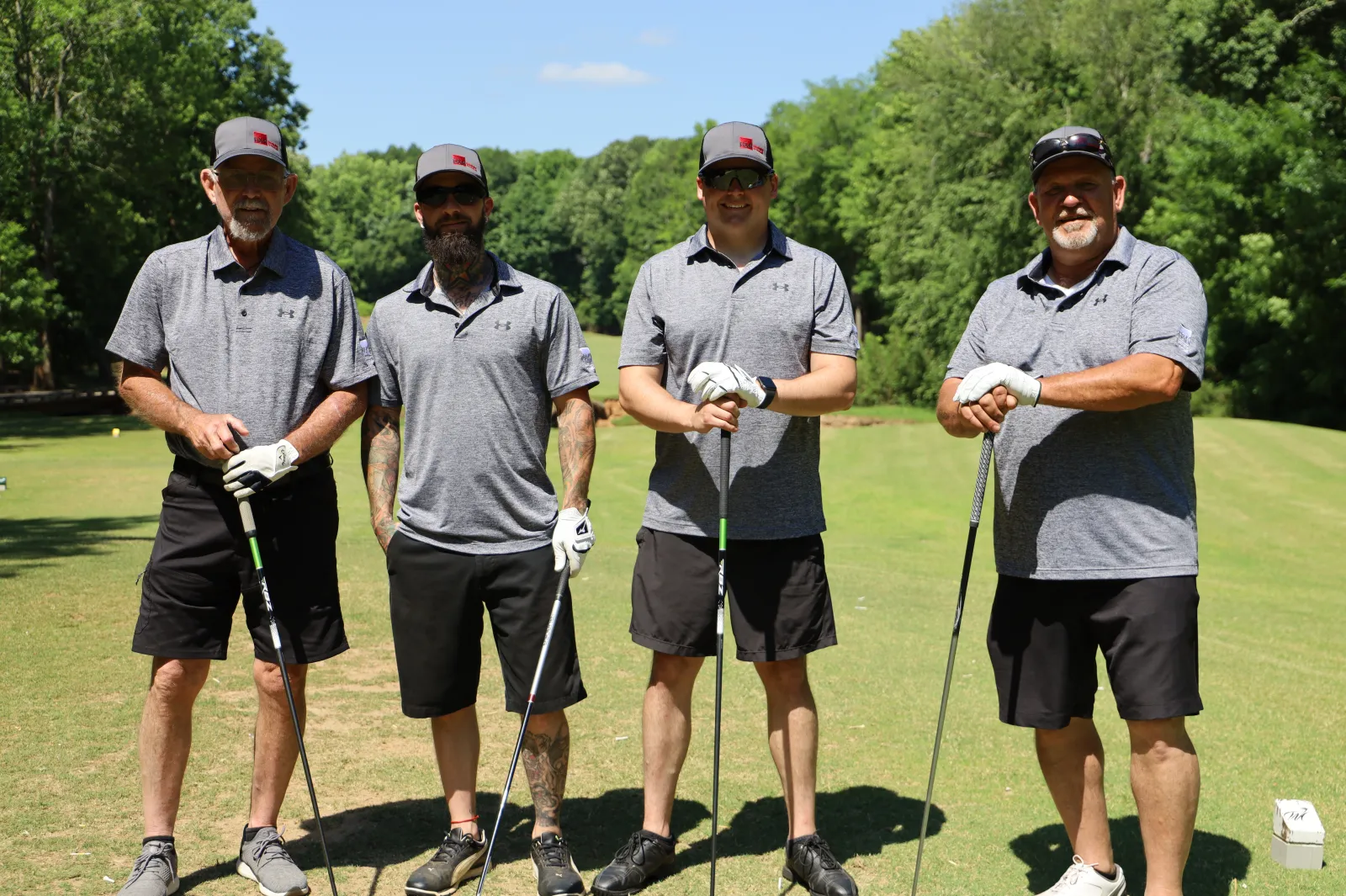 a group of men holding golf clubs