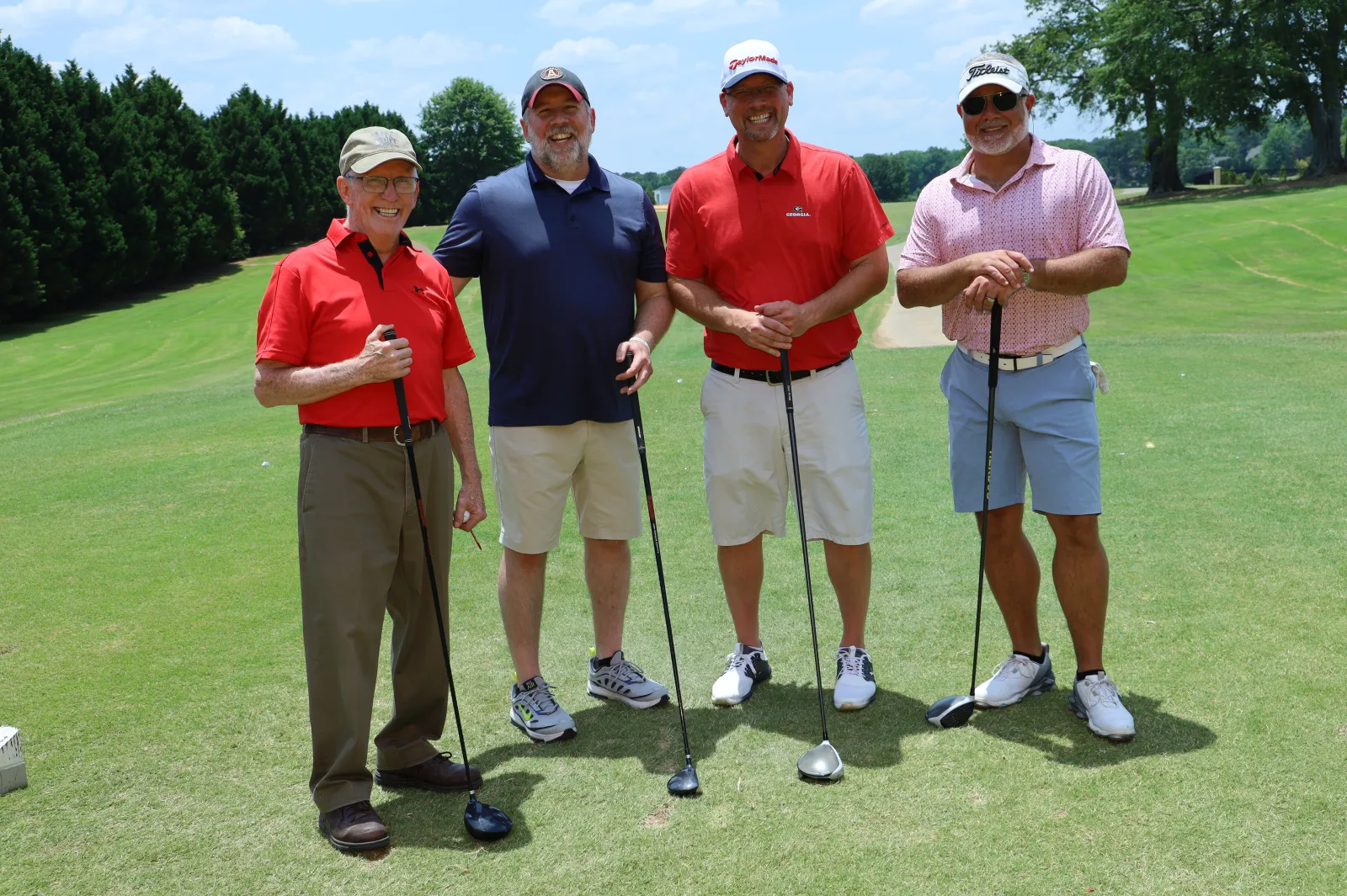 a group of men standing on a golf course