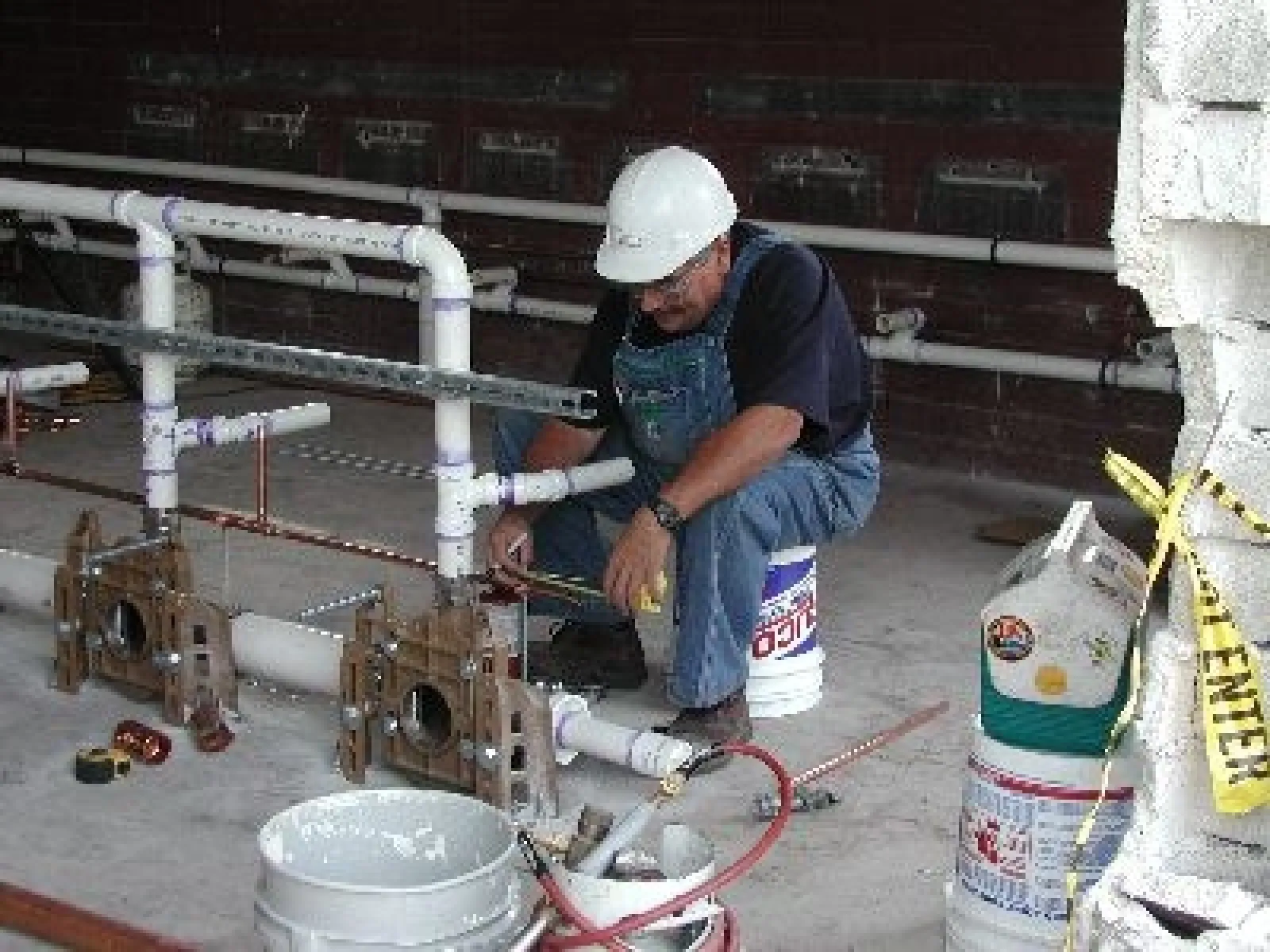 a man wearing a hard hat working on a pipe