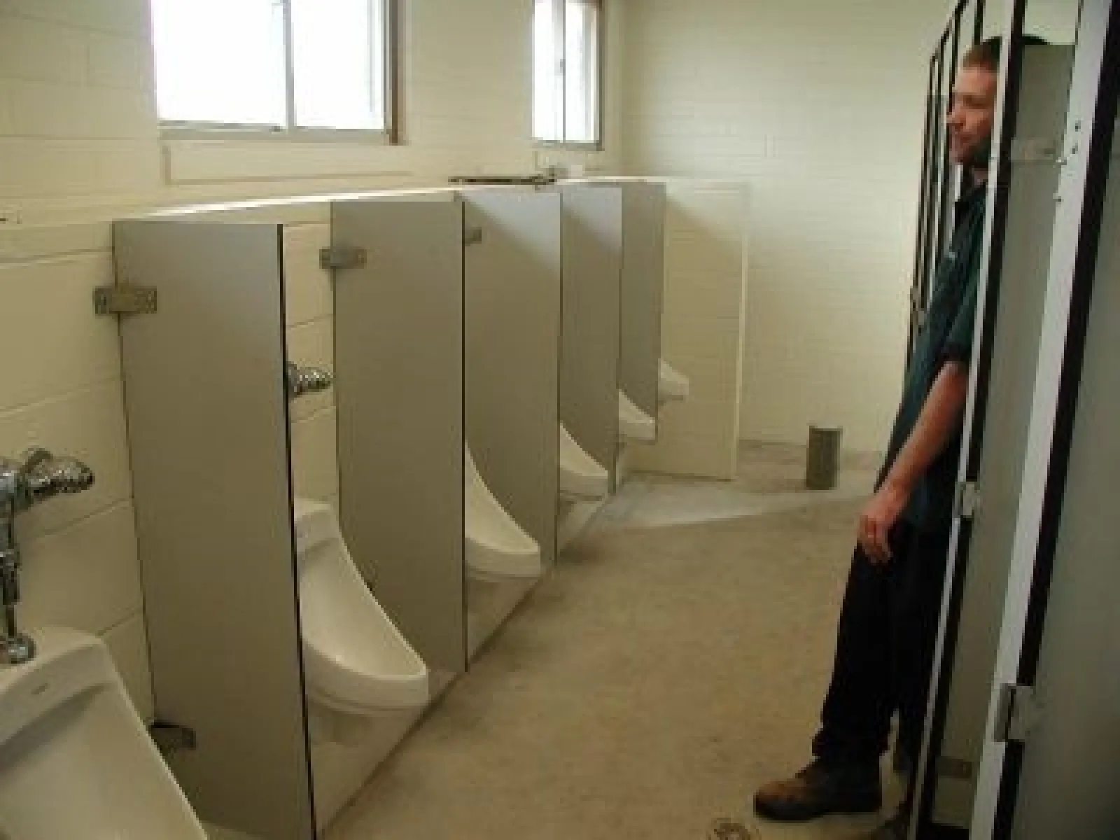 a person standing next to urinals
