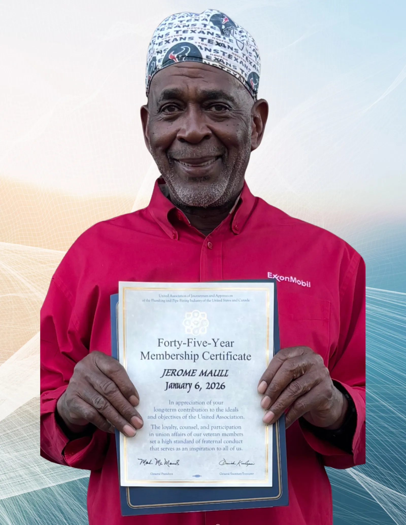 Man in red ExxonMobil shirt and Texans cap holding a Forty-Five-Year Membership Certificate dated January 6, 2026.