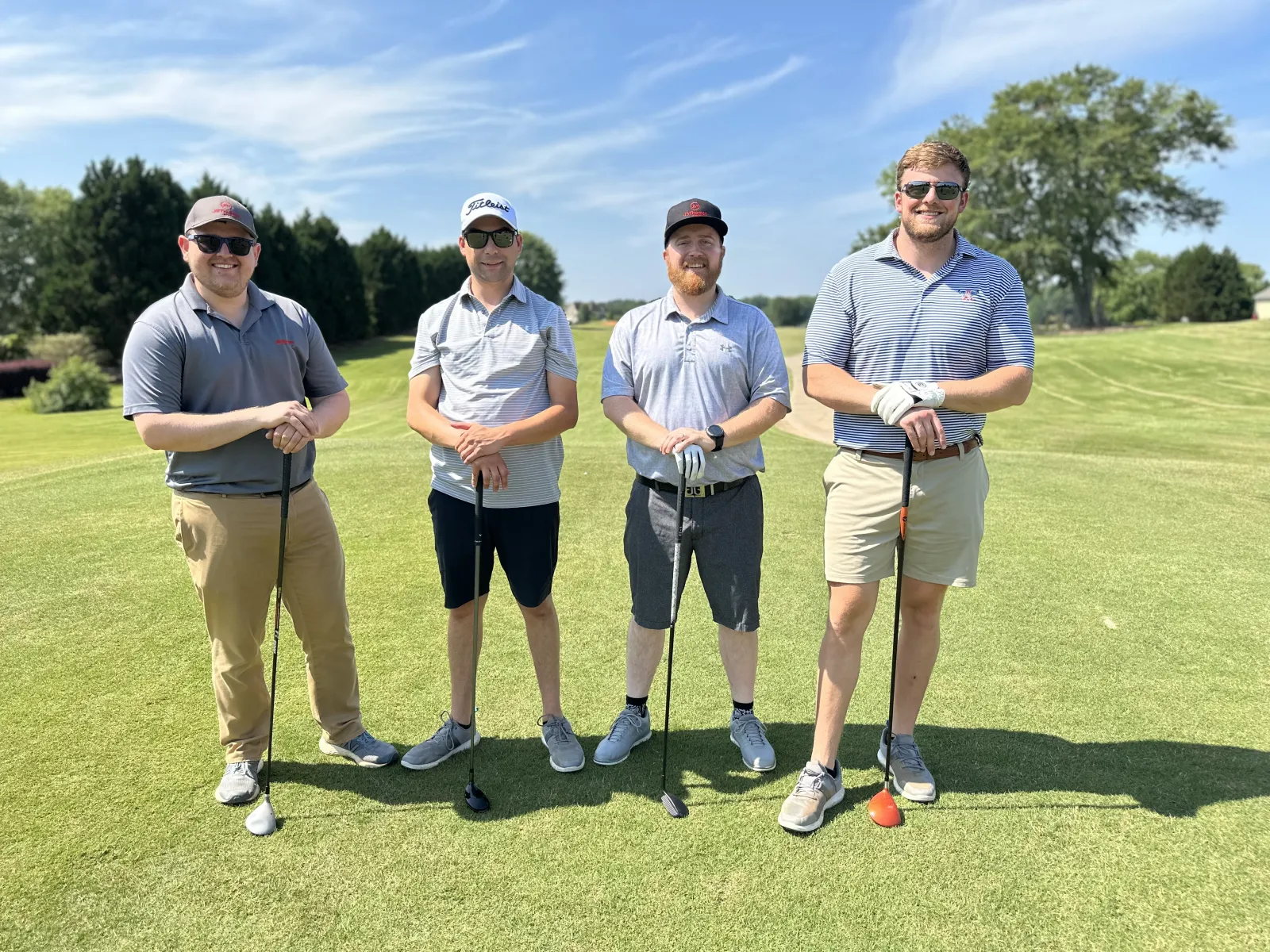 a group of men posing for a picture on a golf course