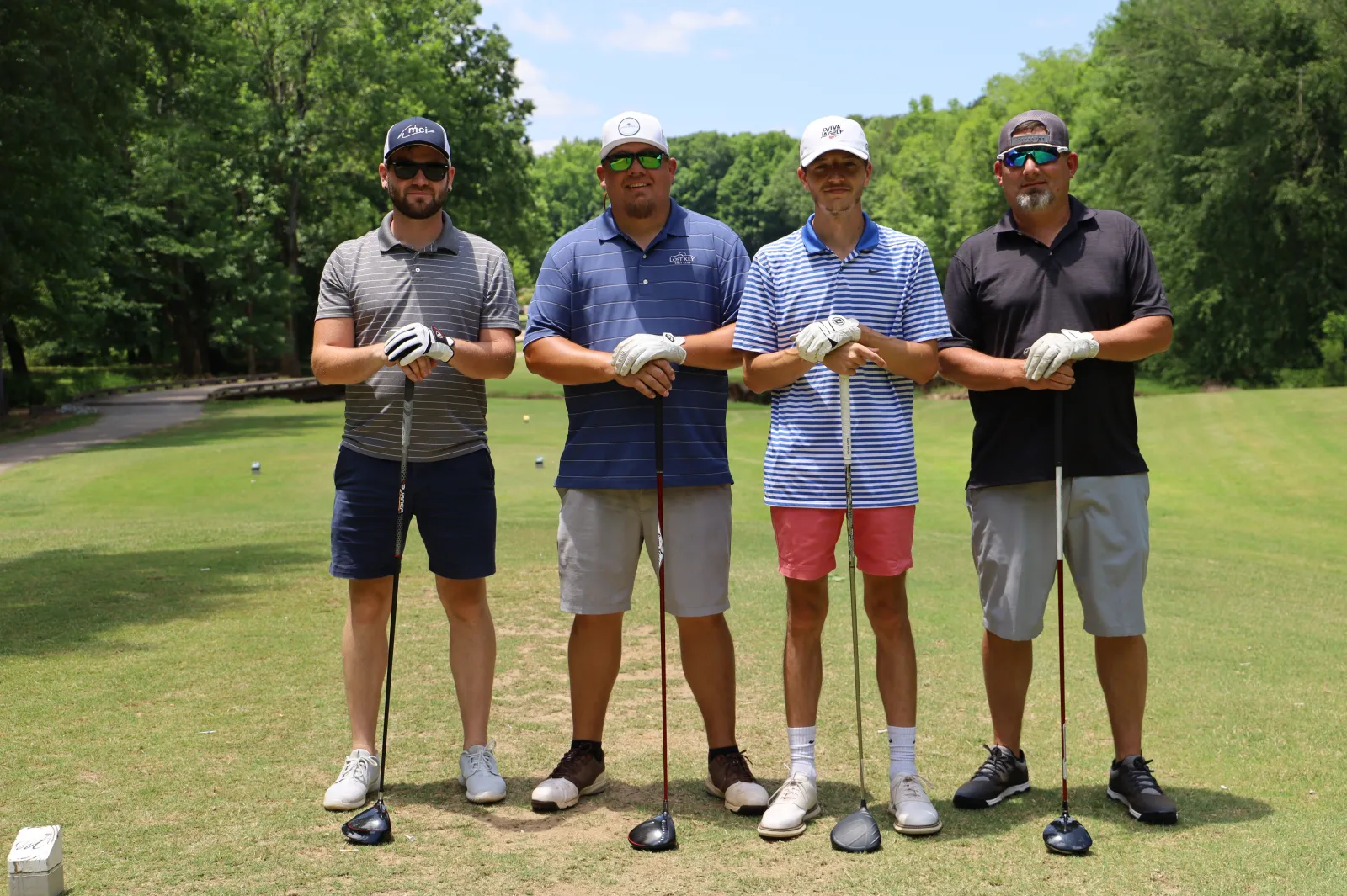 a group of men posing for a picture on a golf course
