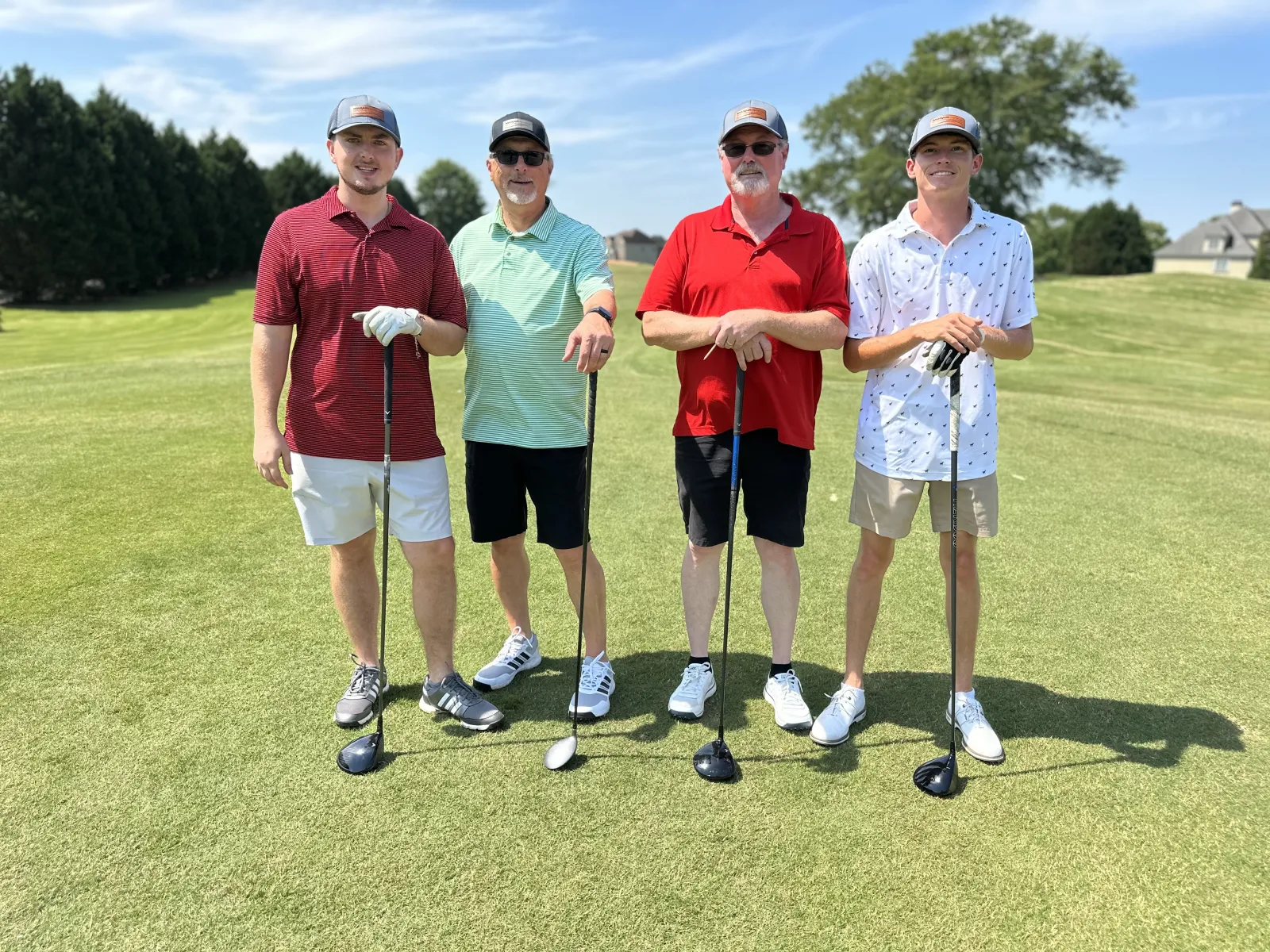 a group of men posing for a photo on a golf course