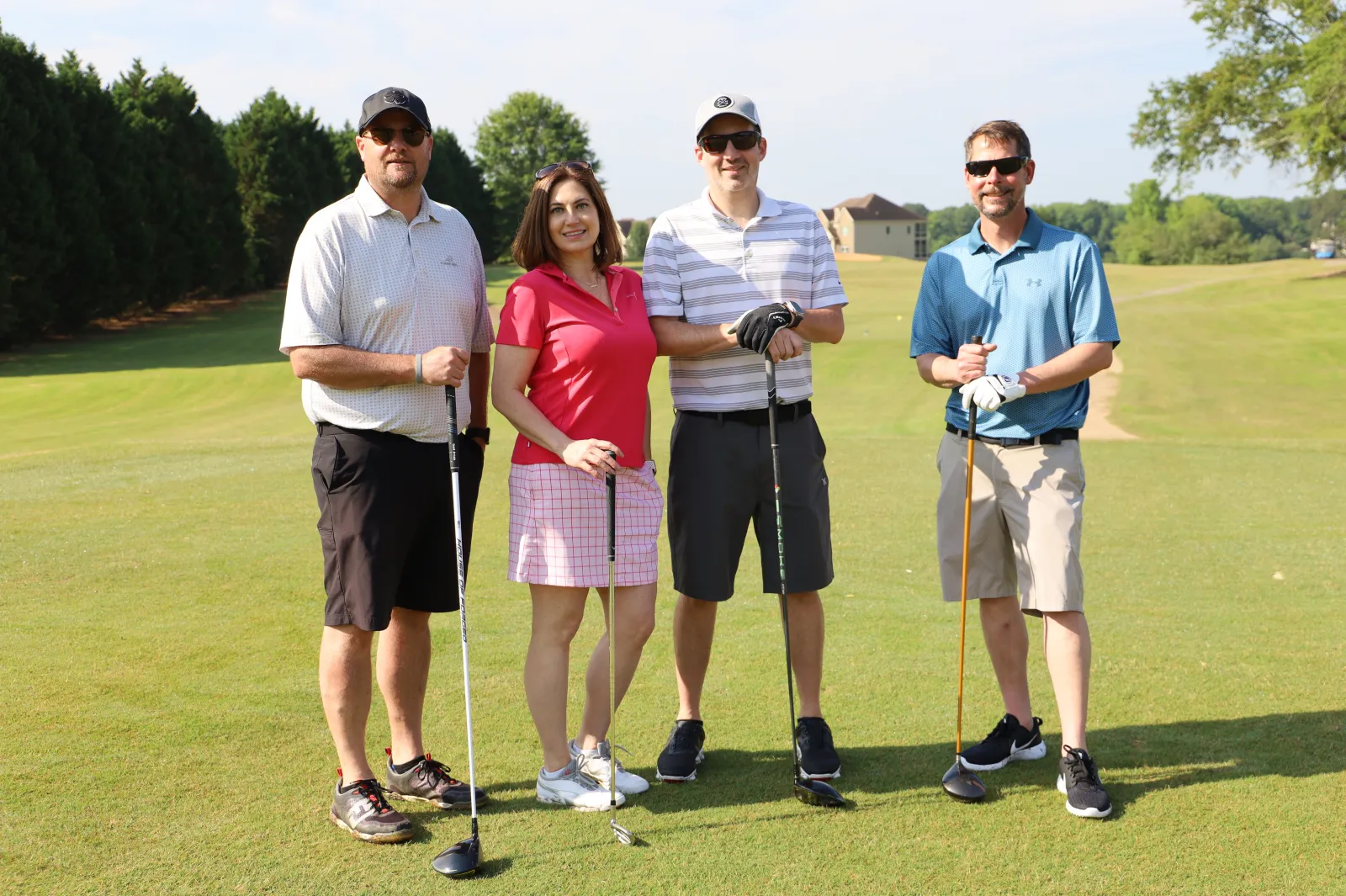a group of people posing for a photo on a golf course