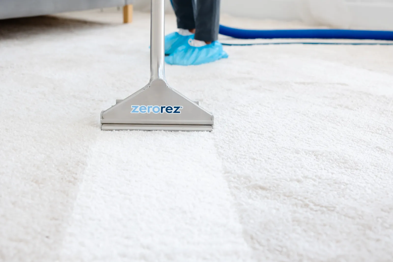 Zerorez® Zr Wand® pulling a clean stripe on a white carpet that was dirty and discolored