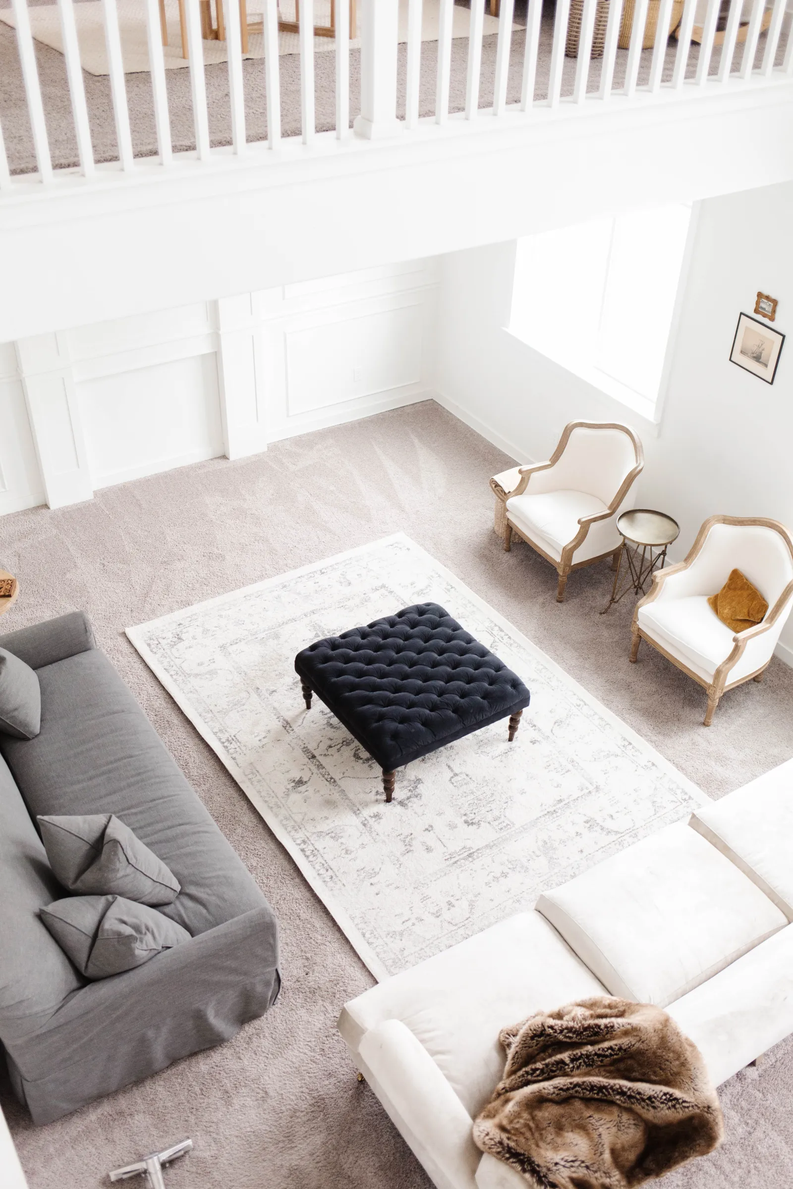 Overhead shot looking down at a living room with a large rug on a carpet, being cleaned before moving out and selling house to improve curb appeal