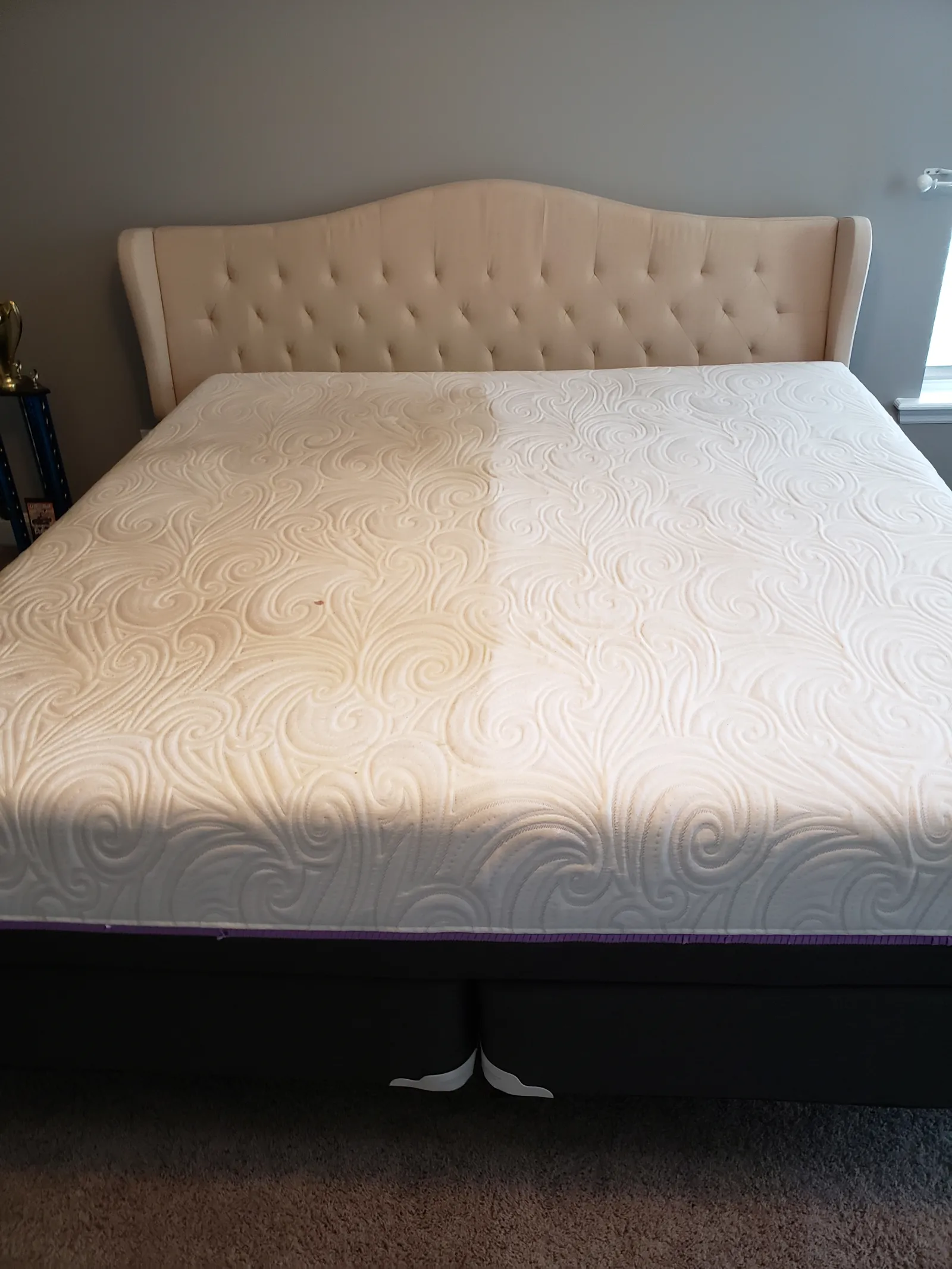bare queen size mattress in a bedroom where the right side has been professionally deep cleaned by Zerorez and the left, dirty, yellow side, hasn't been