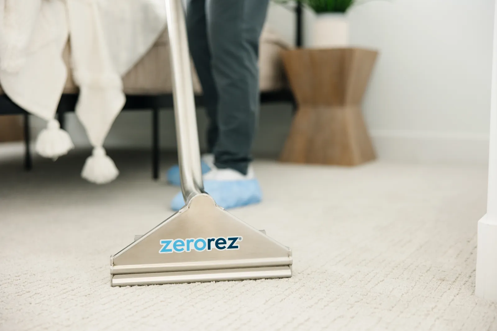 Close up of the front of a Zerorez Zr Wand deep cleaning a textured white hypoallergenic carpet in a dining room