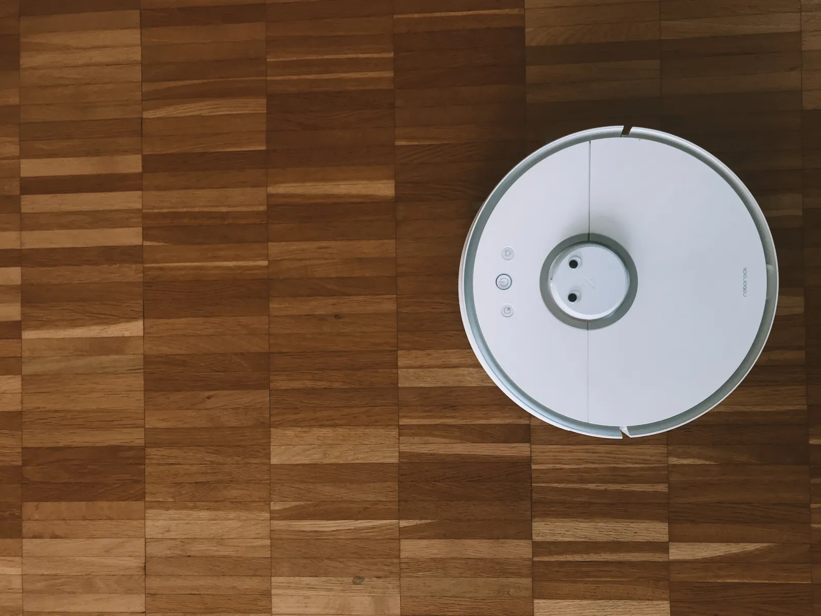 white robot vacuum cleaning hardwood floors