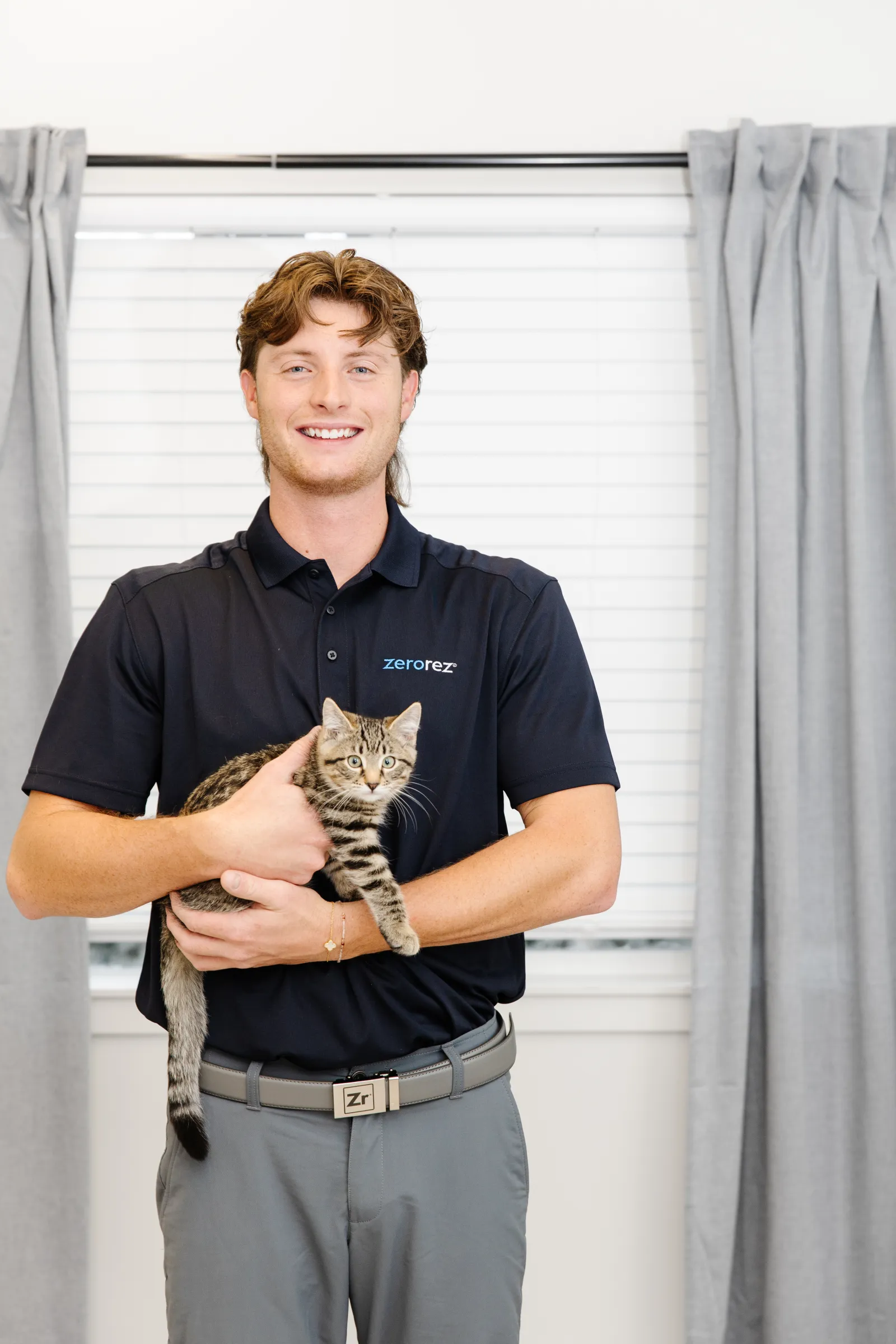 zerorez carpet technician holding a brown and black cat