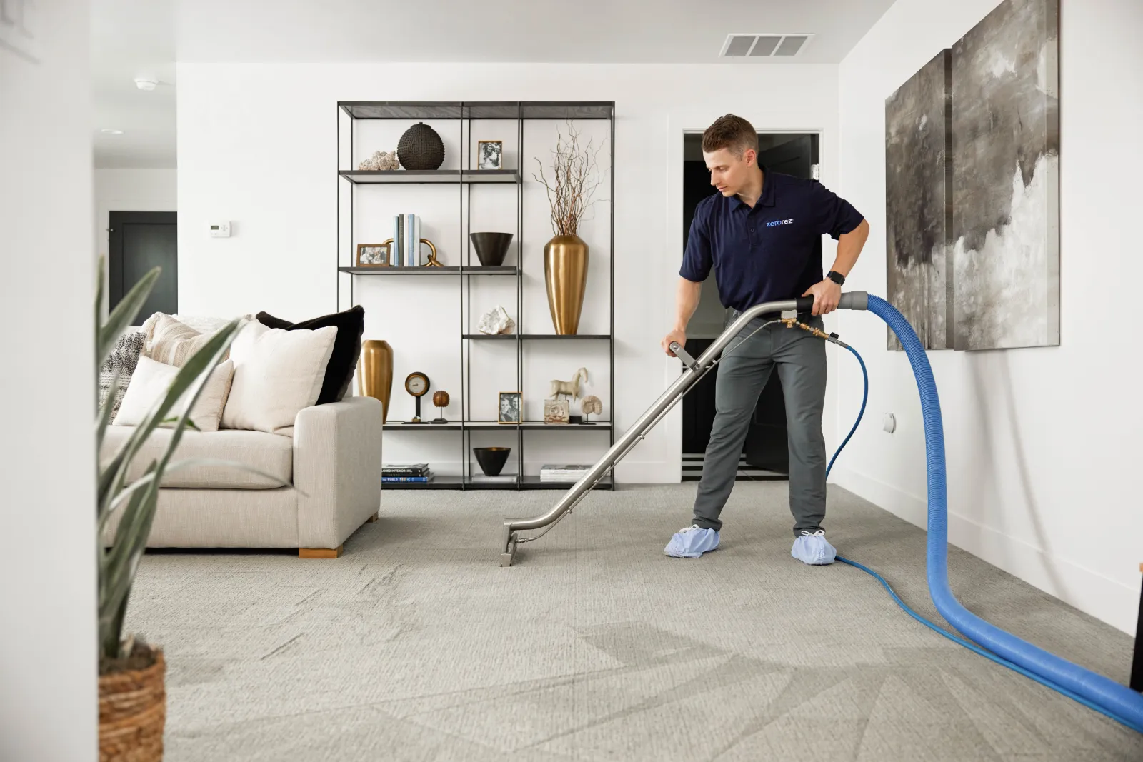 carpet cleaner with wand cleaning carpet in a room with cream carpet