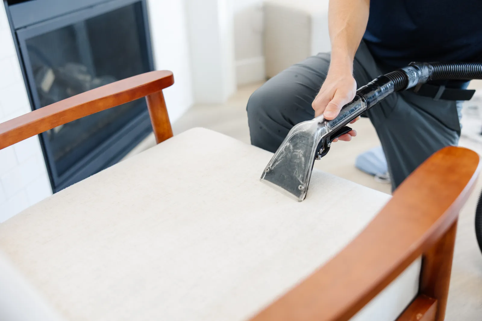 technician cleaning an upholstery tan chair