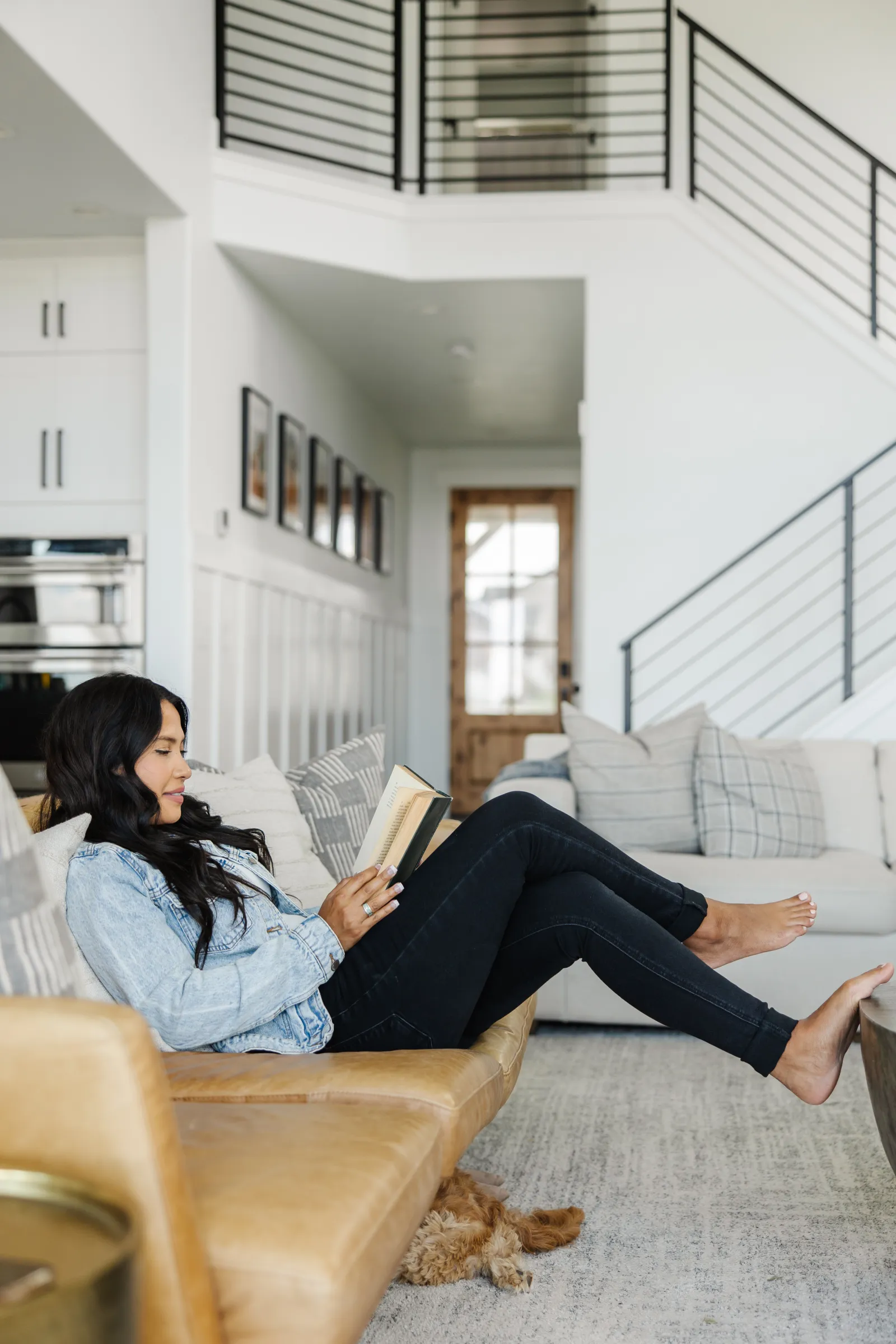 homeowner reading a book on couch in a living room