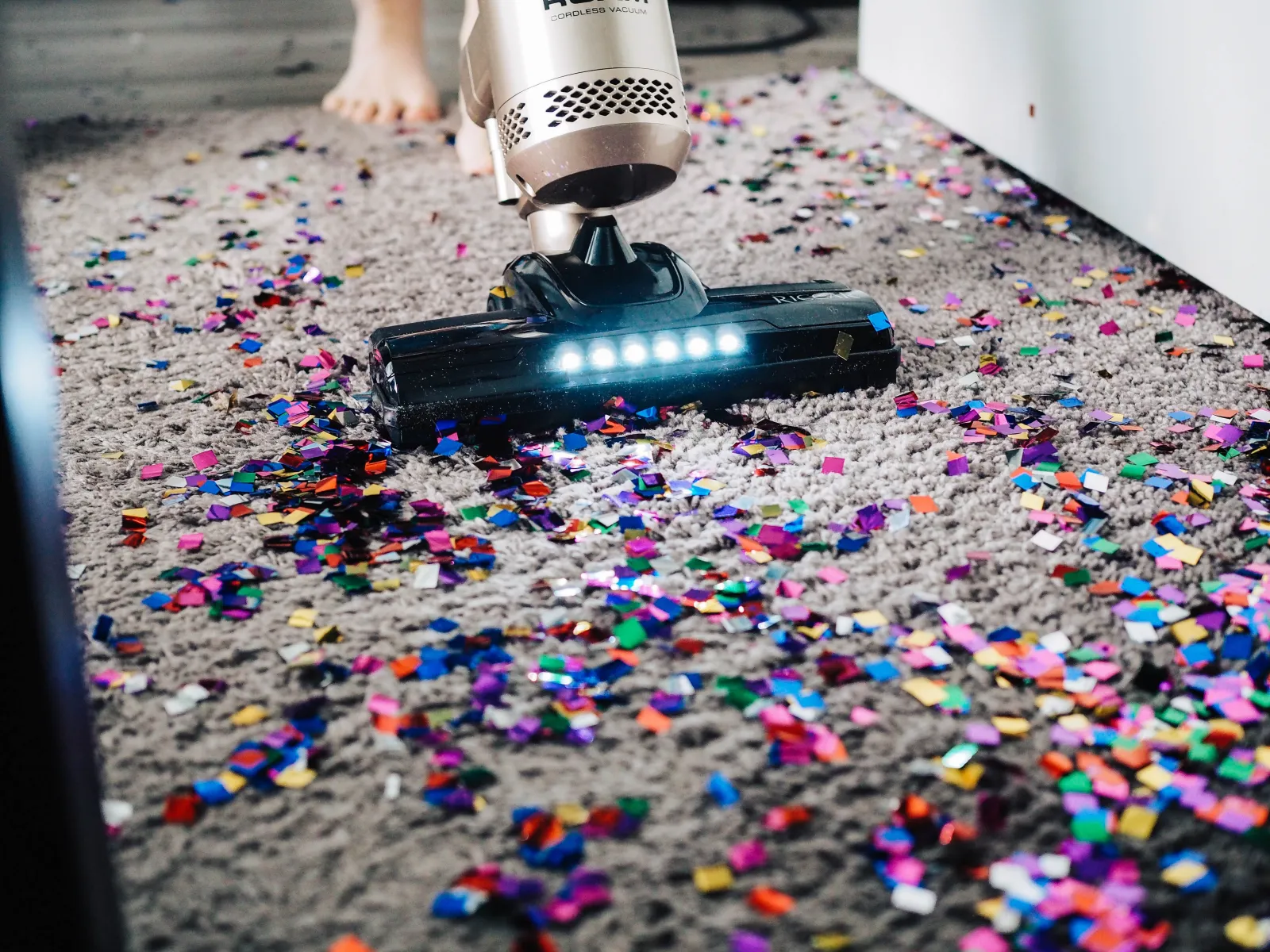 close up of vacuum sucking up confetti off a floor