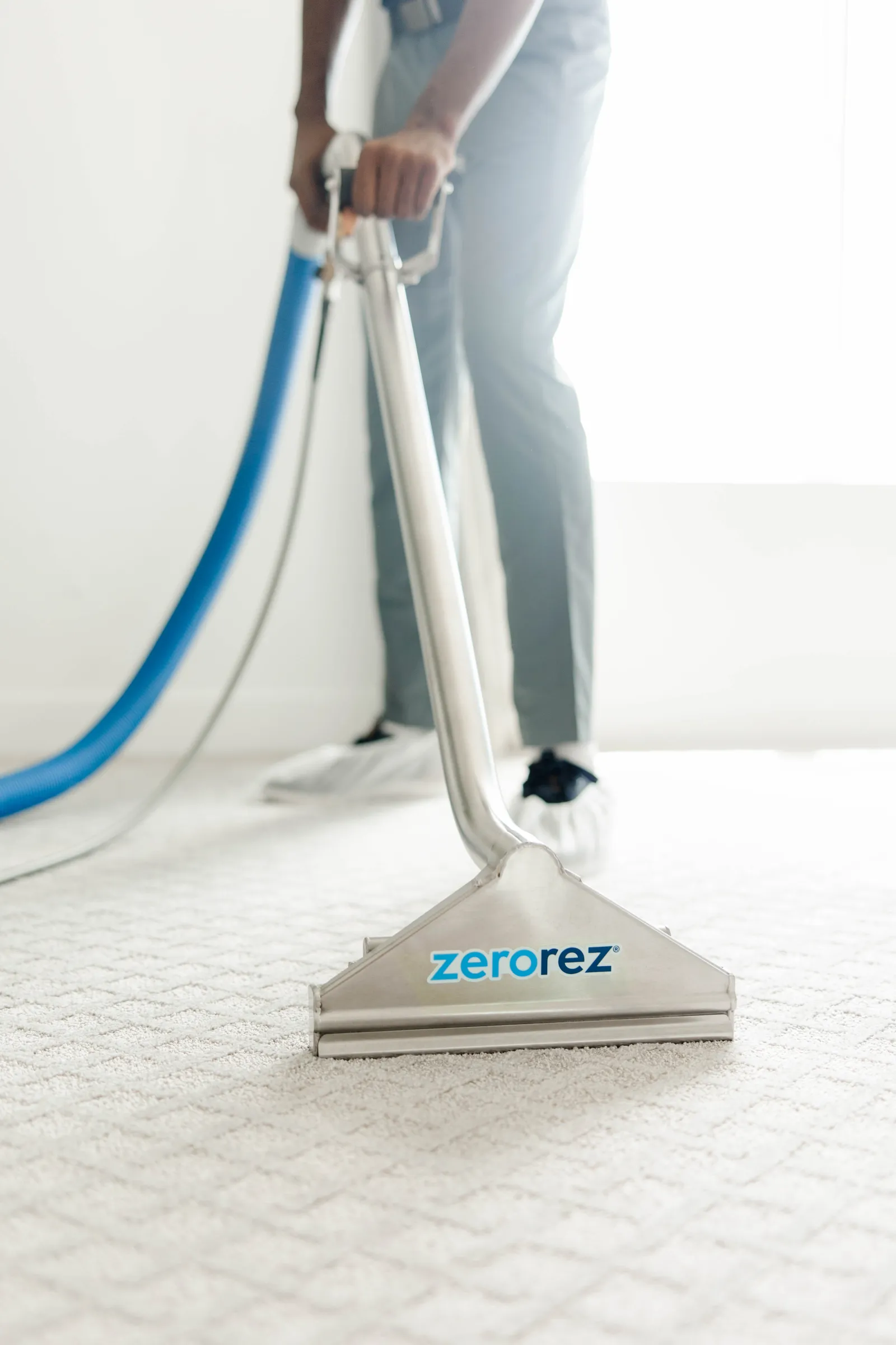 Zerorez technician using the Zr Wand to clean a white carpet good for allergies and asthma sufferers